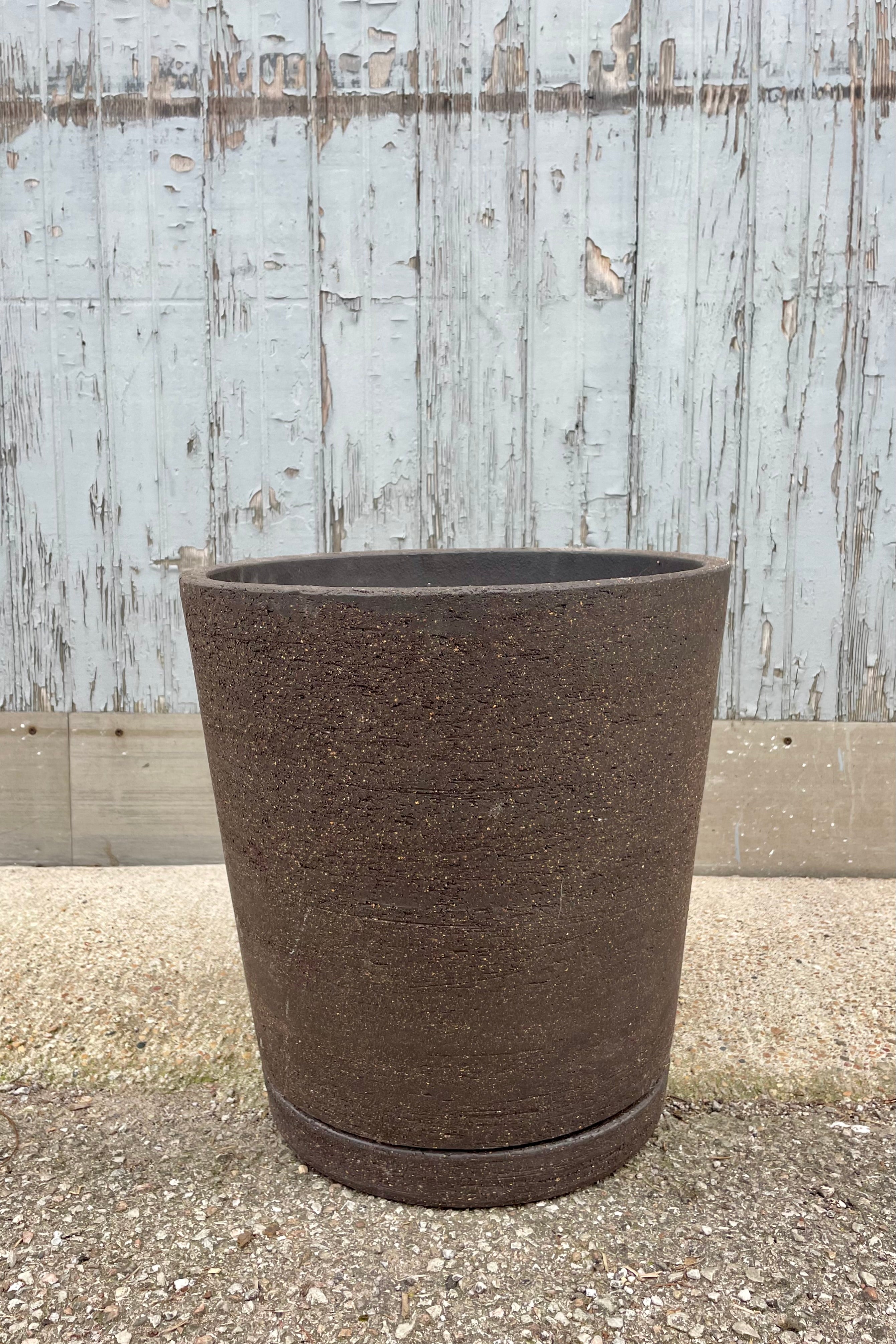 Peat colored I/O tapered planter in large showing the rough texture on the brown clay. Shown against a gray wall.