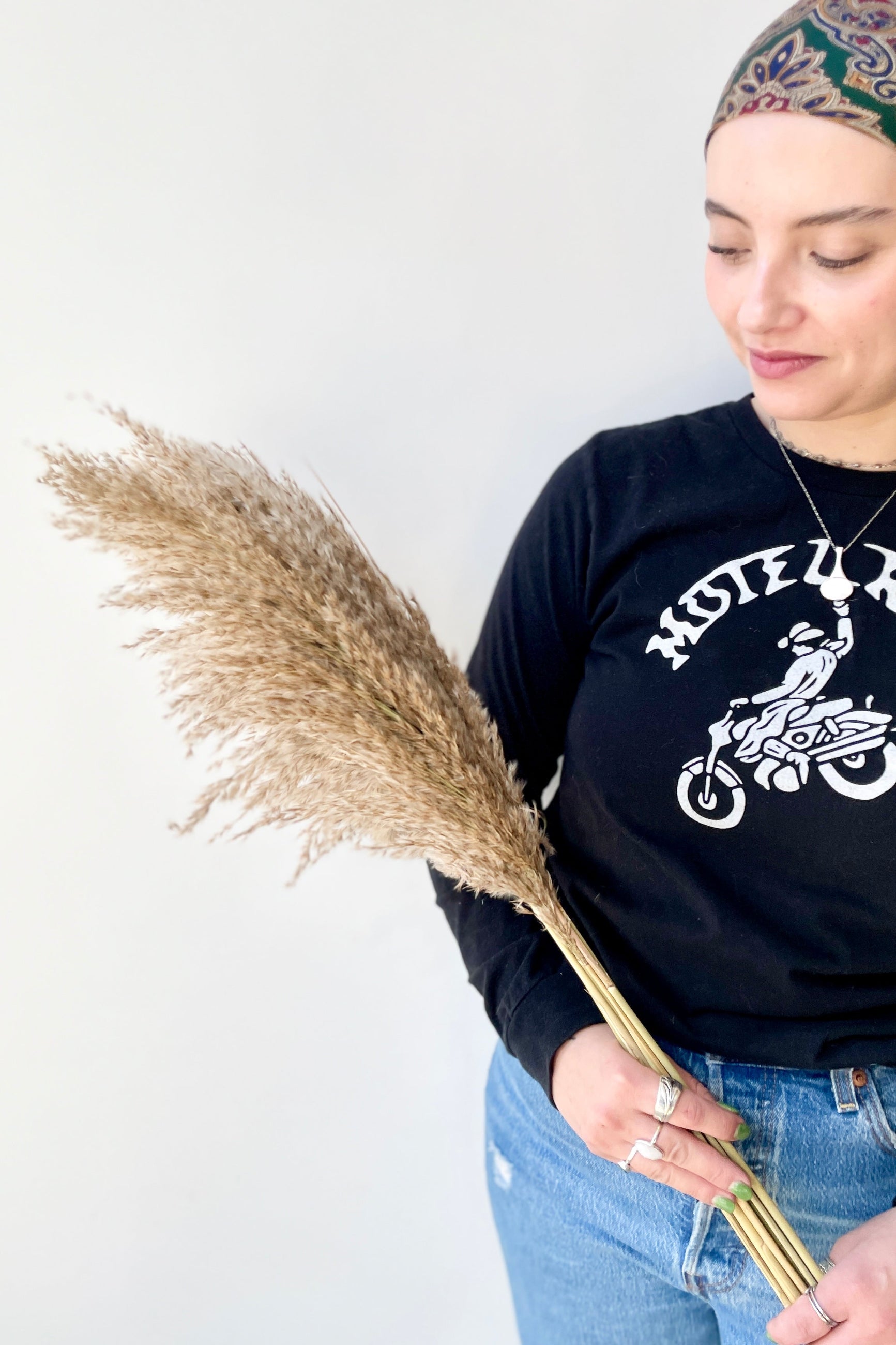 Pluma Mini natural color preserved at Sprout-home. Staff member holding one bunch