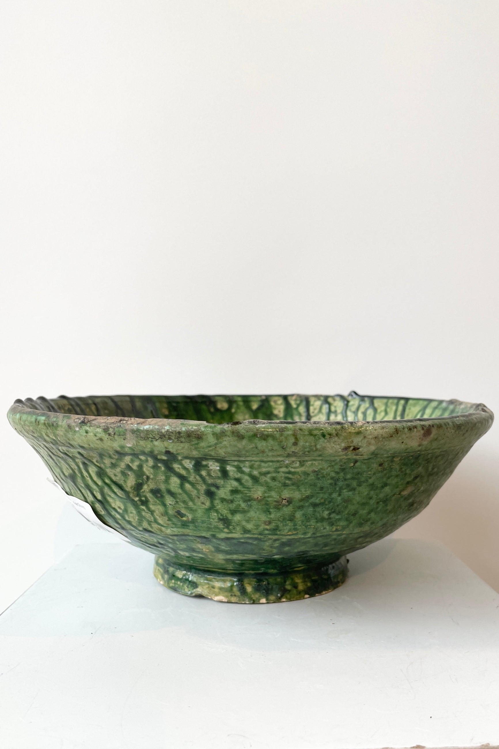 The Green medium Tamegroute bowl shown from the side against a white wall at Sprout-home.