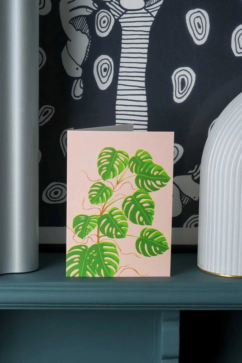 Monstera greeting card by Stengun Drawings siting on a shelf in a lifestyle shot.