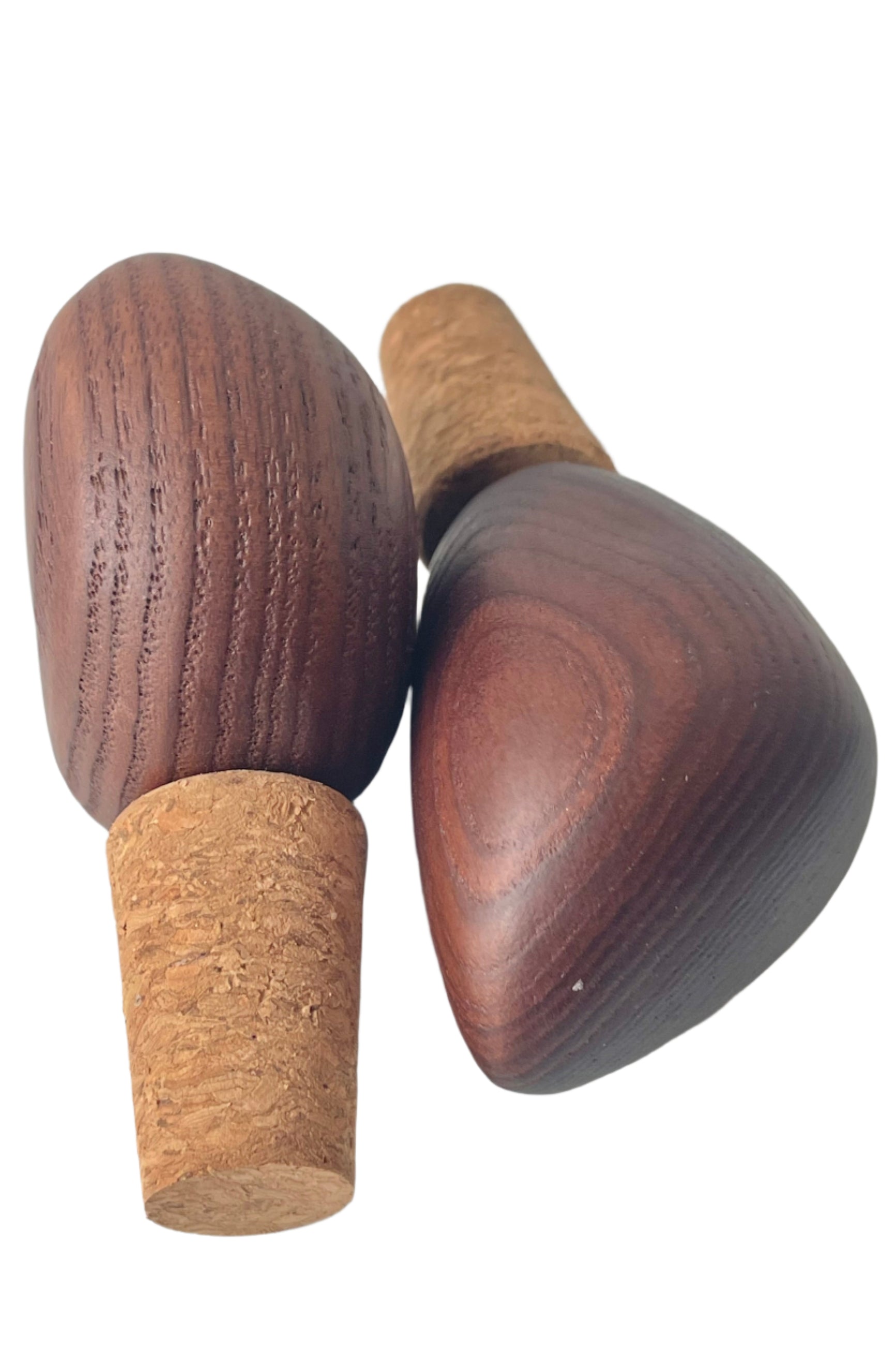 Photo of a pair of wood-topped cork bottle stoppers or wine stoppers.  The warm wood tones and wood grain are visible. Shown on a white background ©Sprout Home