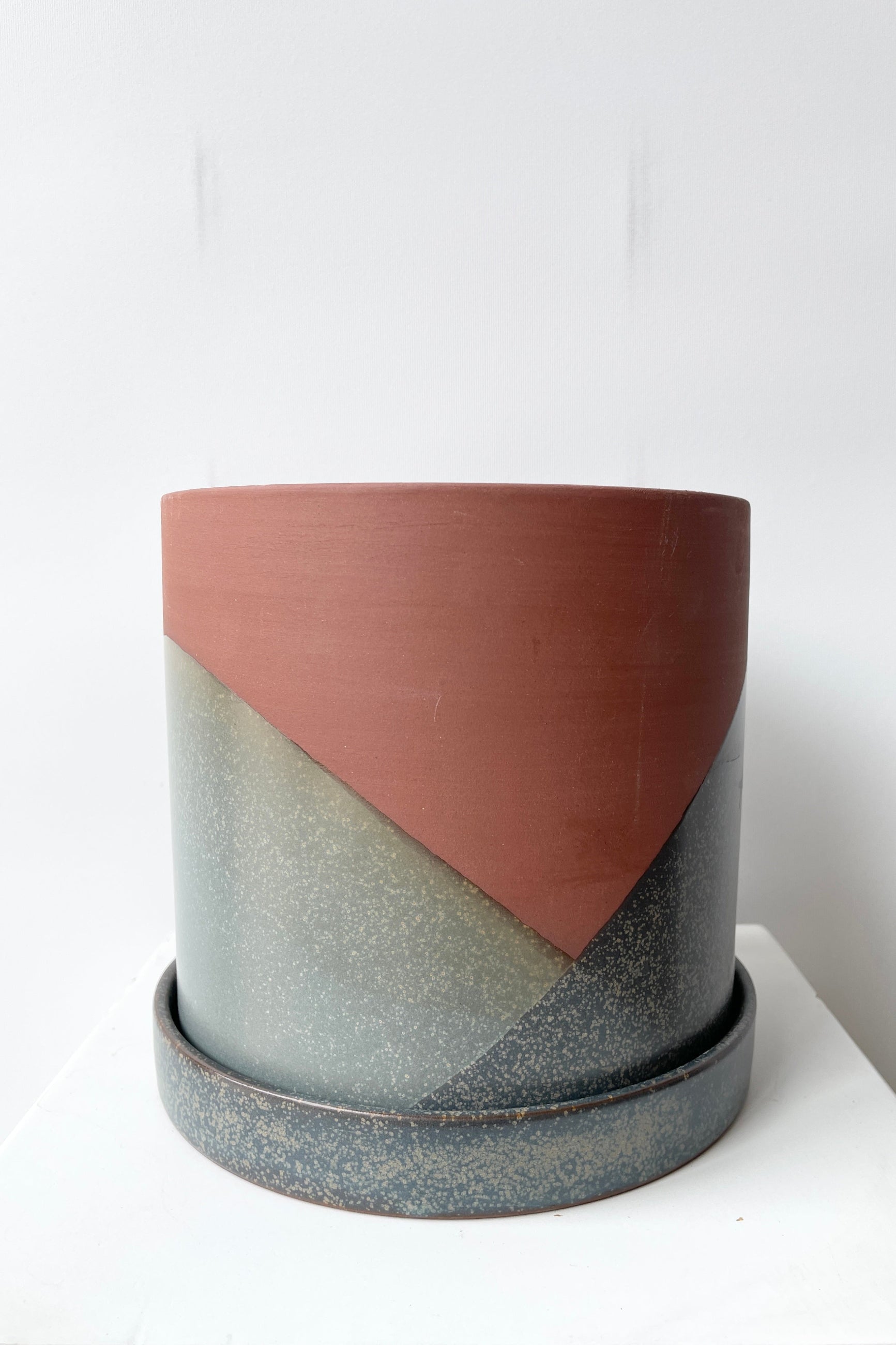 El Cerro pot shown at eye level from the side with its blue and terracotta colors against a white wall ©Sprout Home