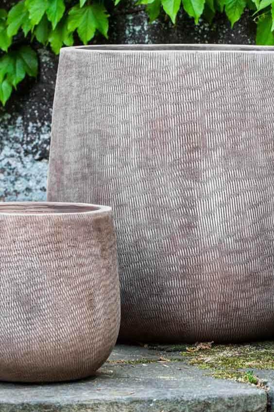 Small and large handspum linen antico planters with the smaller one slightly in front and both empty.