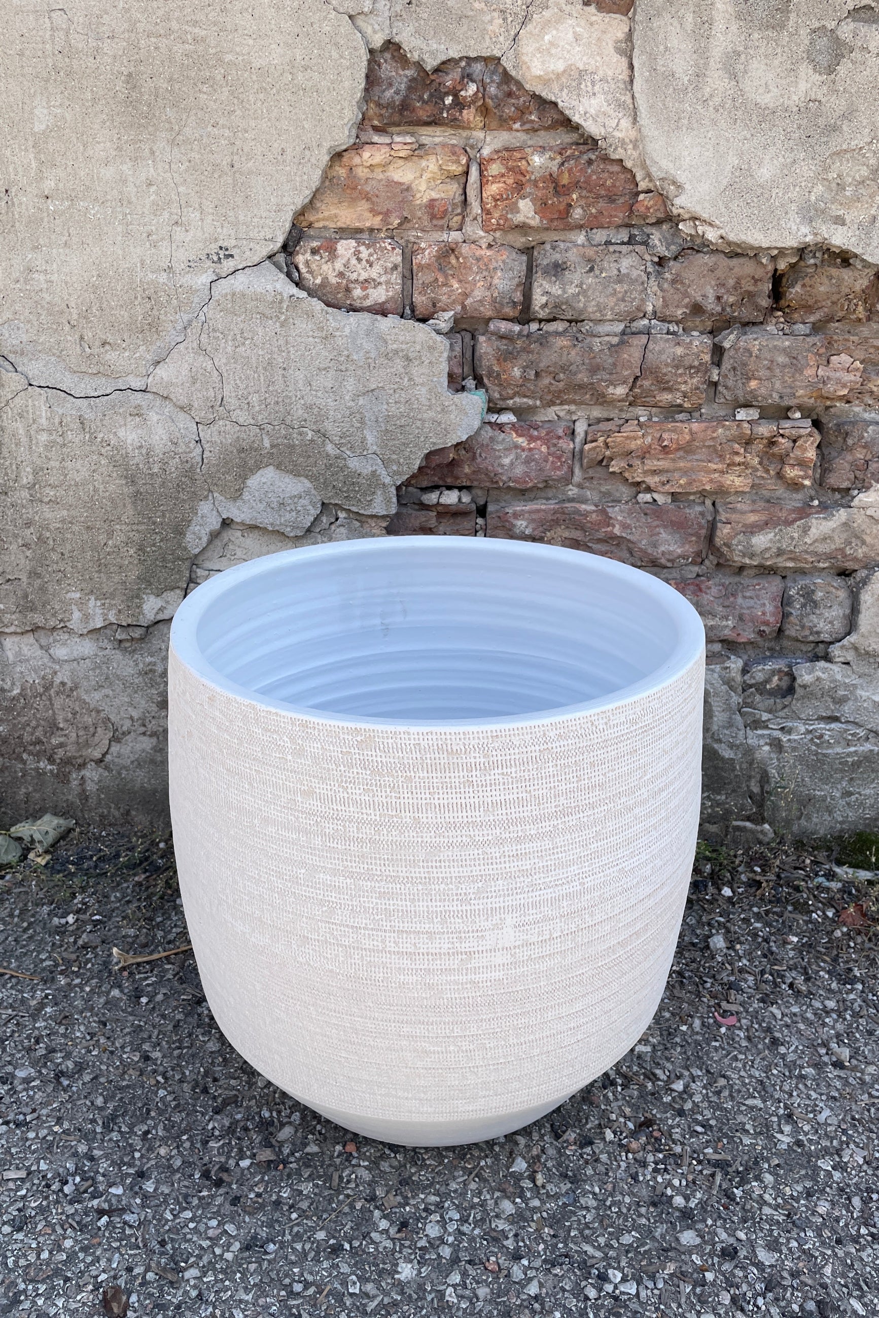 Ray pot white 13.5" shown from topside looking in sitting on a concrete floor ©Sprout Home
