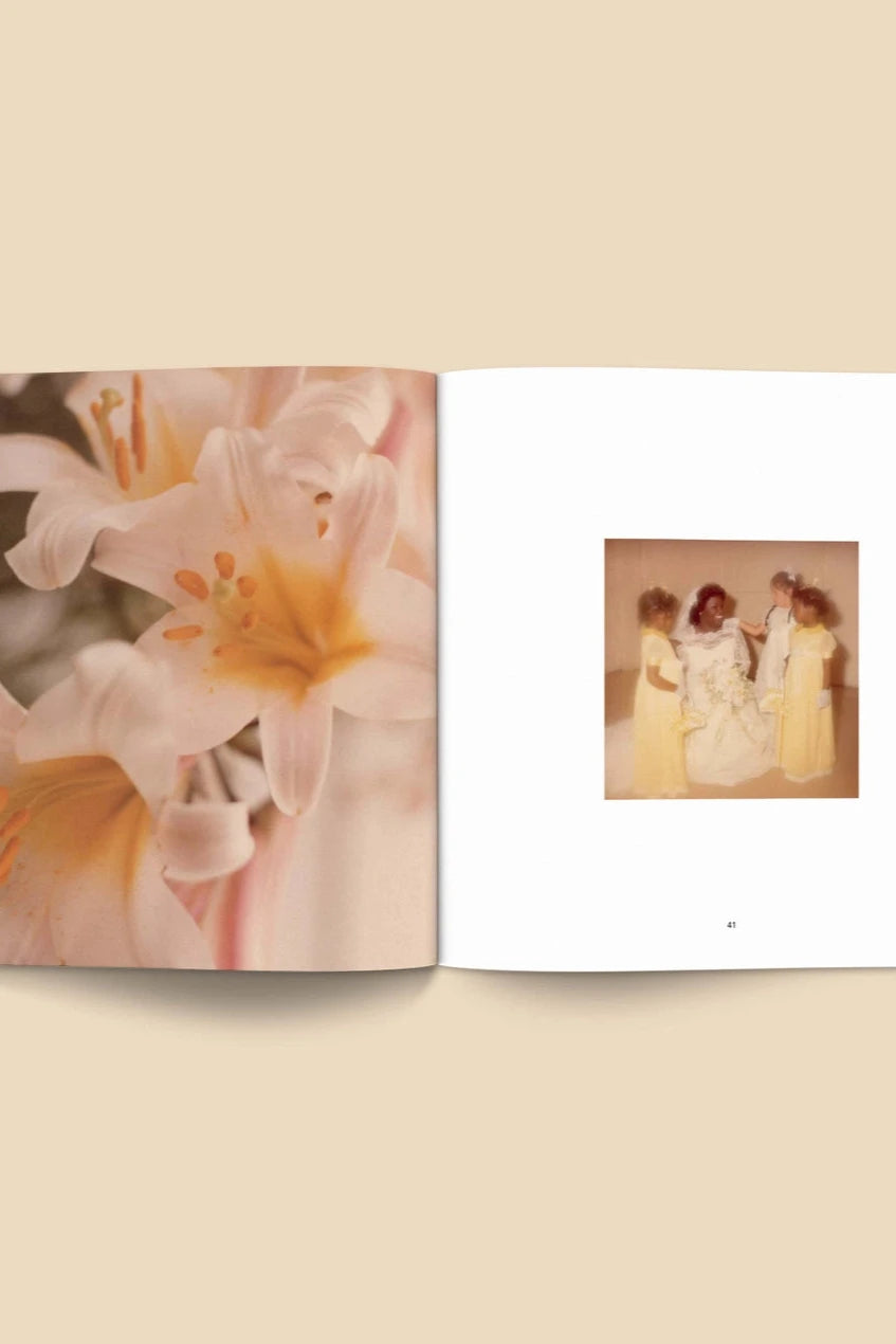 Forgotten Flowers Coffee Table Book by Broccoli  open to a page with lilies and a vintage wedding photo