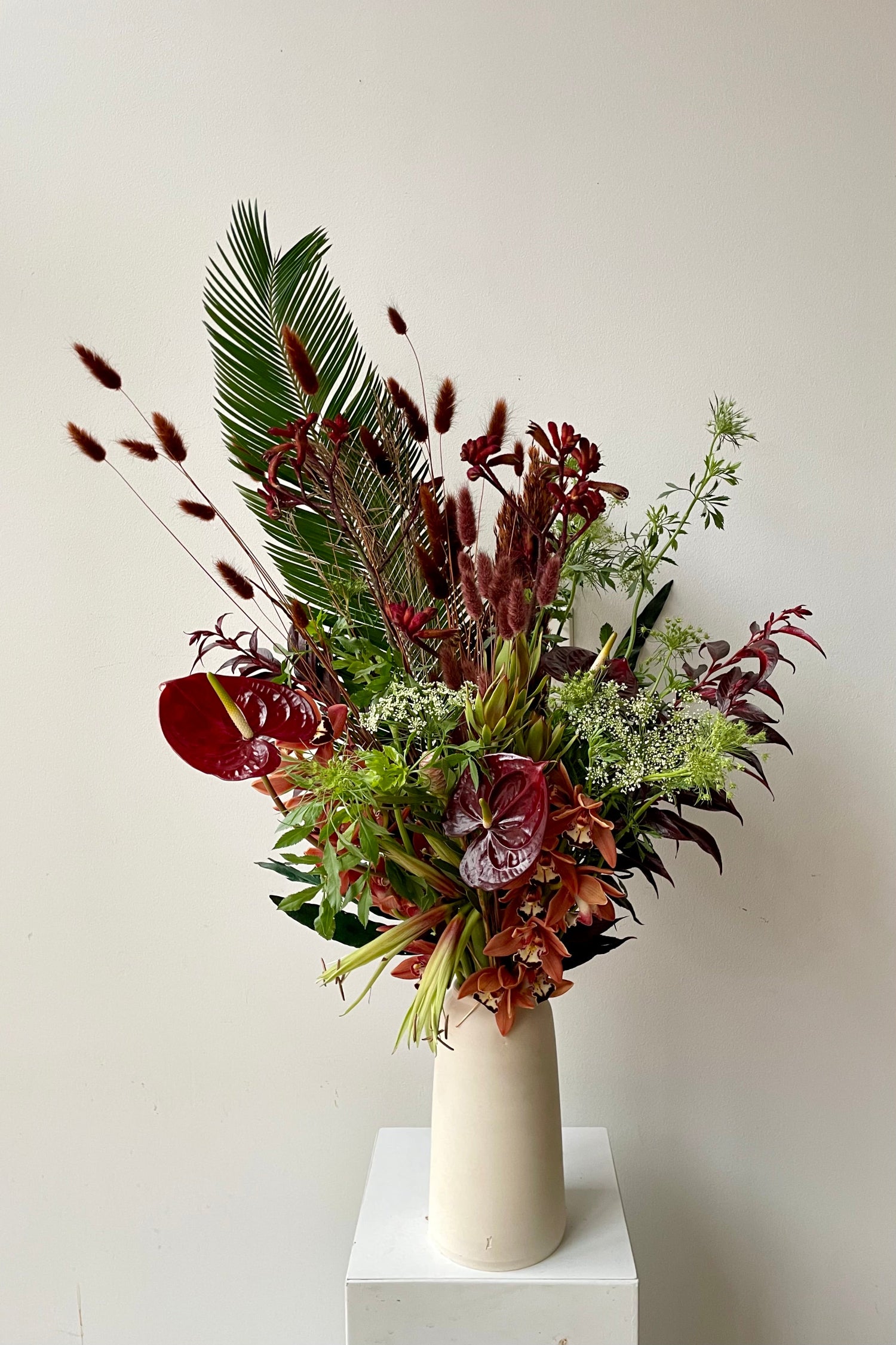 A sexy tropical floral arrangement by Sprout-home featuring preserved lagers, anthurium, orchids and palm in a L'Impatience vase.  Photo by Sprout-home
