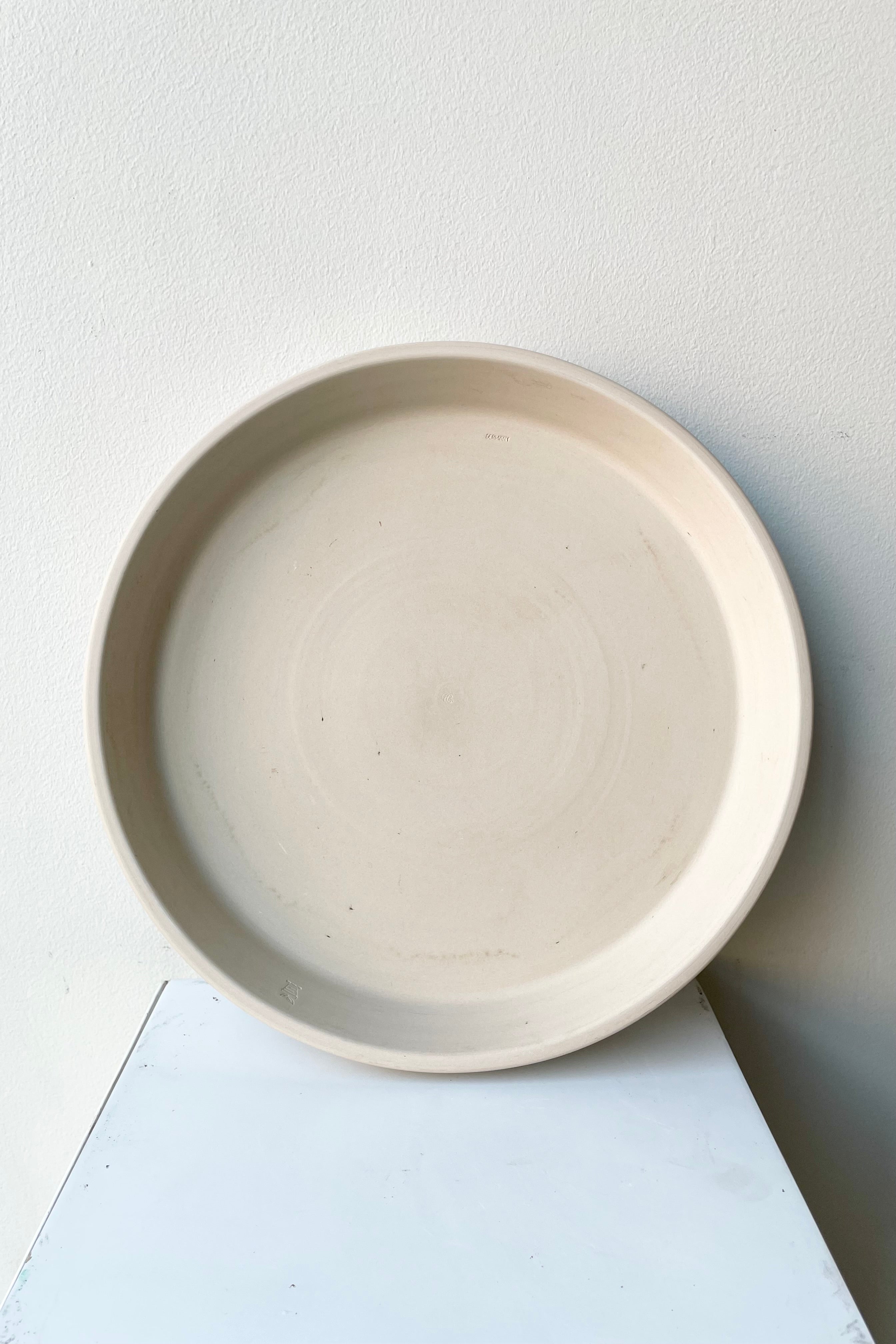 The Clay Saucer in Granite color to fit a 12" pot sitting on its side viewable from the top.