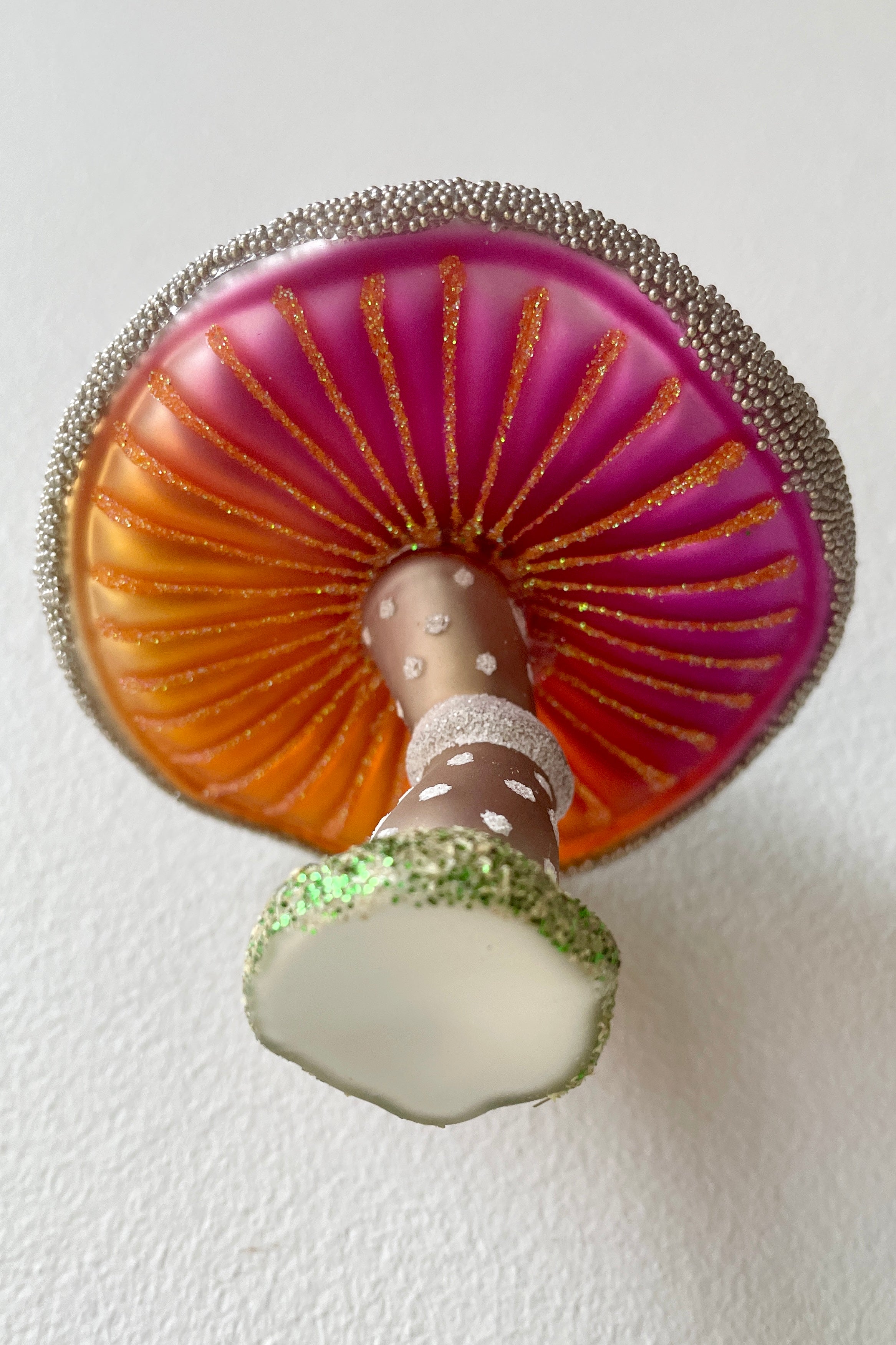 The underside of the Purple Wooded Glen Mushroom ornament with vivid brand and fuchsia at Sprout-home. 