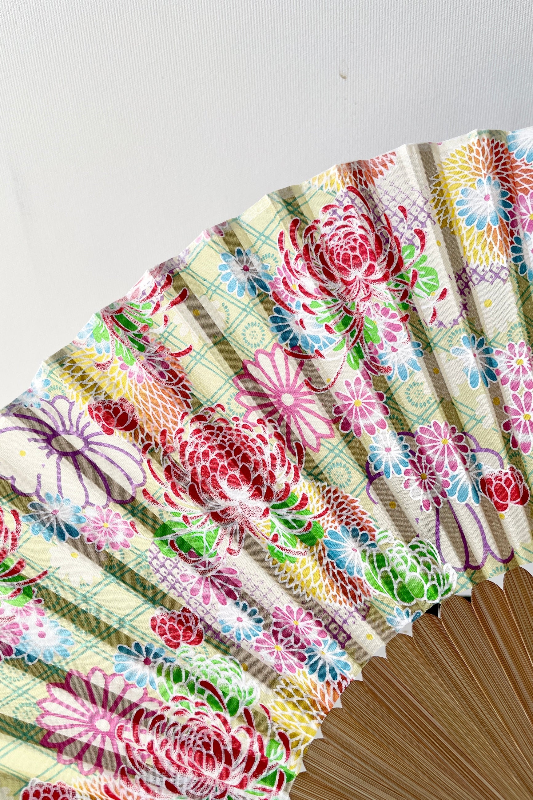 Silk fan pale green with chrysanthemums  showing a detail of the pattern.