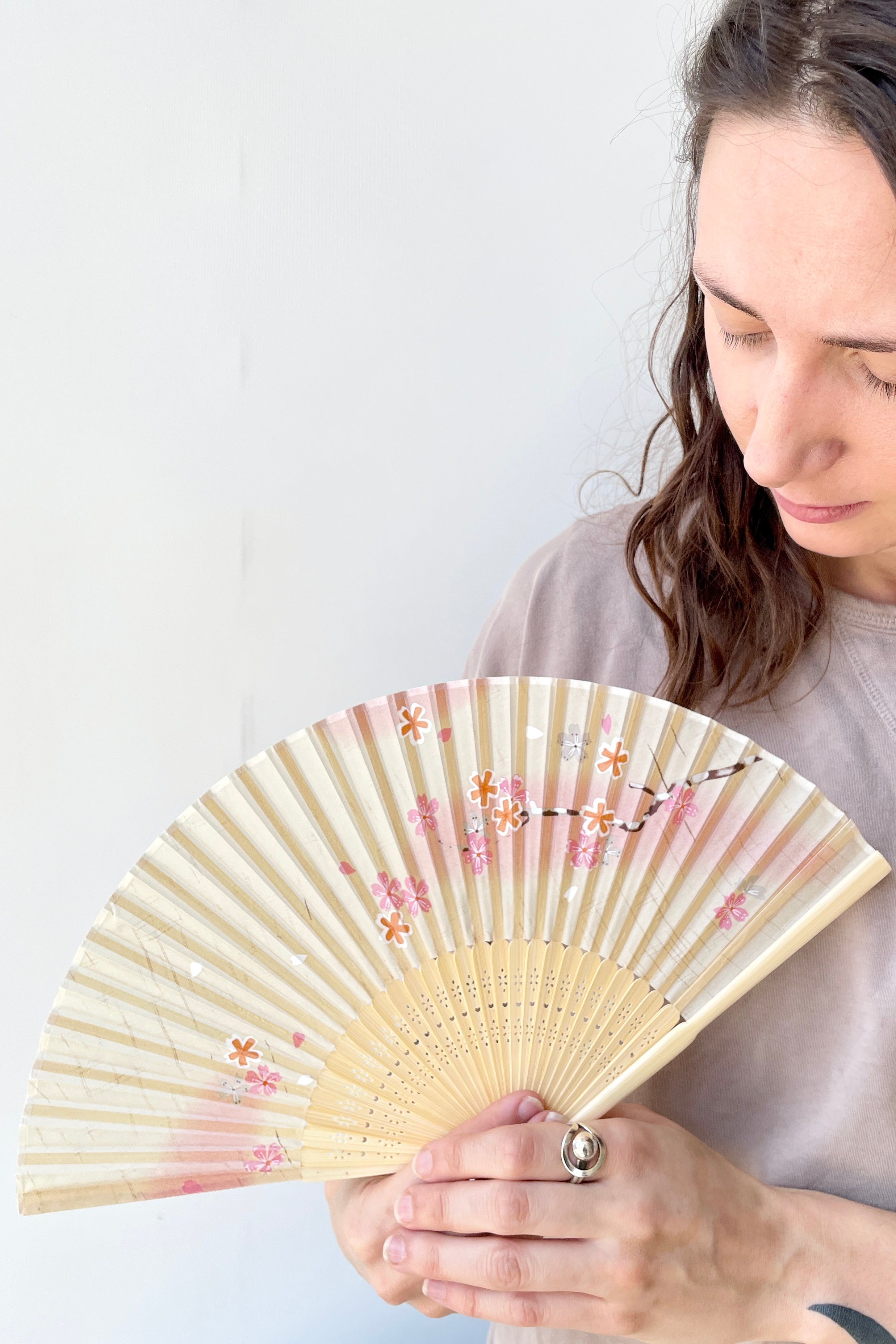 Silk fan white and pink cherry blossoms being held by a Sprout-home team member ©Sprout Home