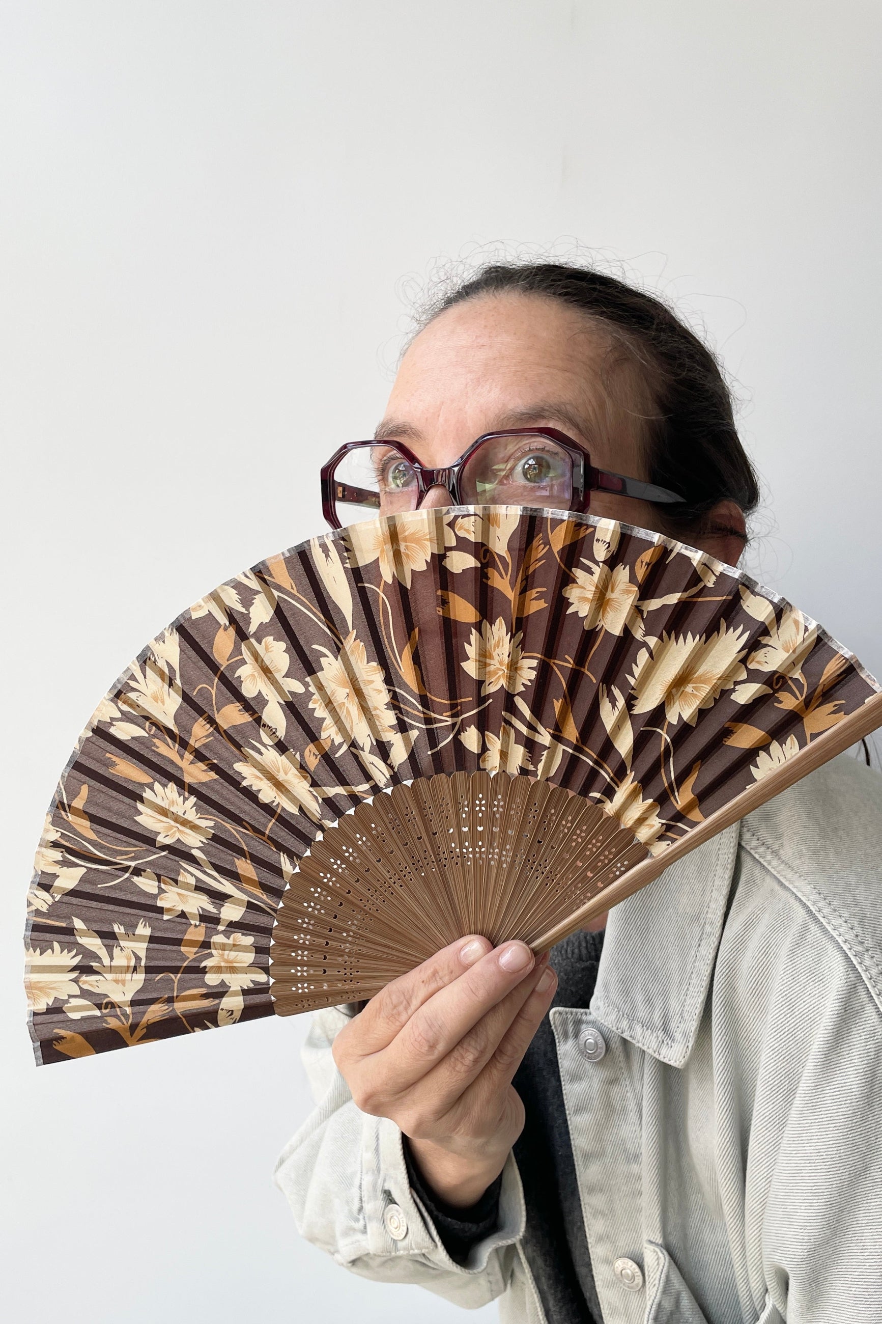 Silk Fan brown flowers with brown bamboo being held by Tara at Sprout-home.