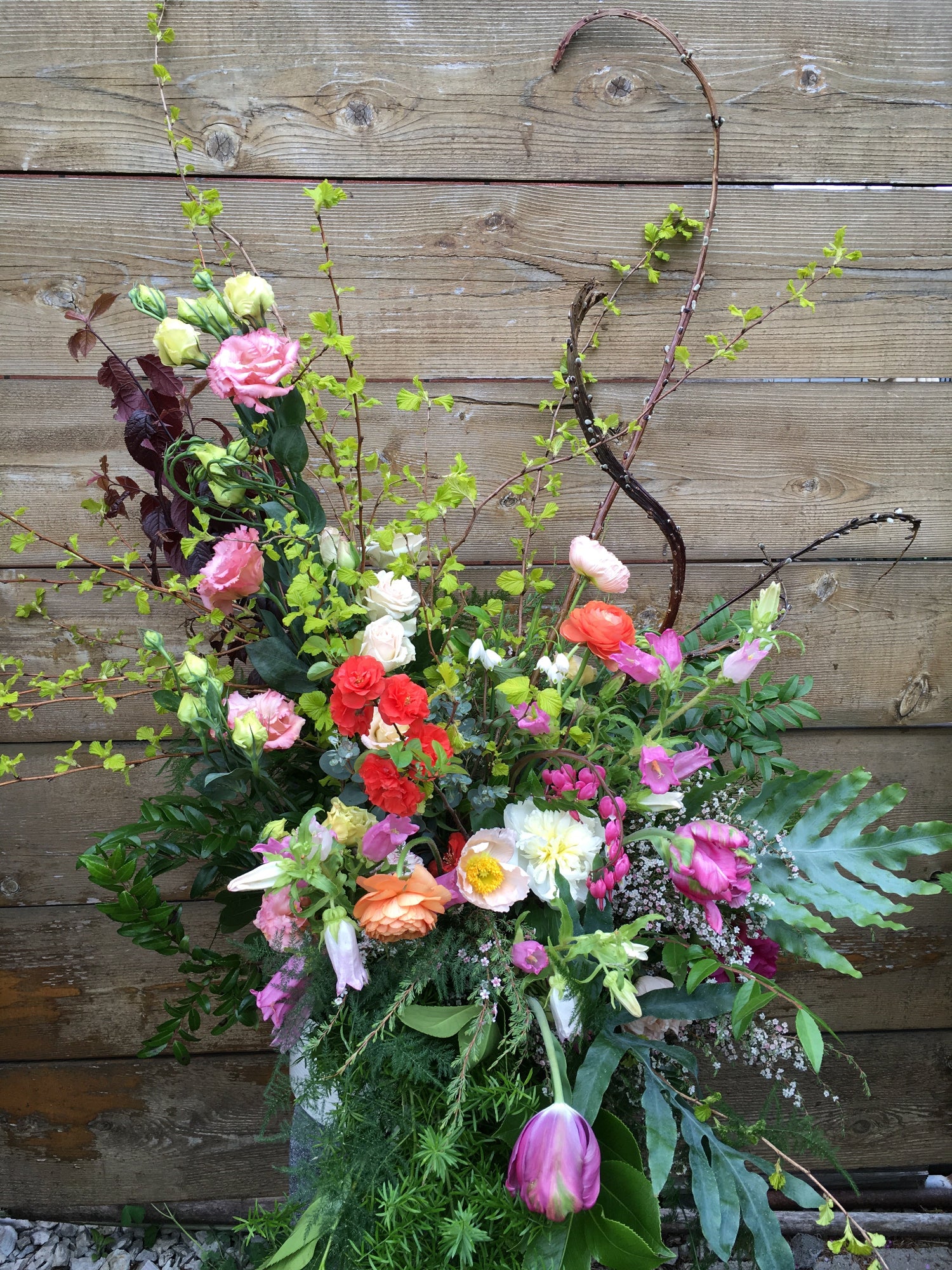 Floral installation in a garden style against a wood backdrop by Sprout-home. 