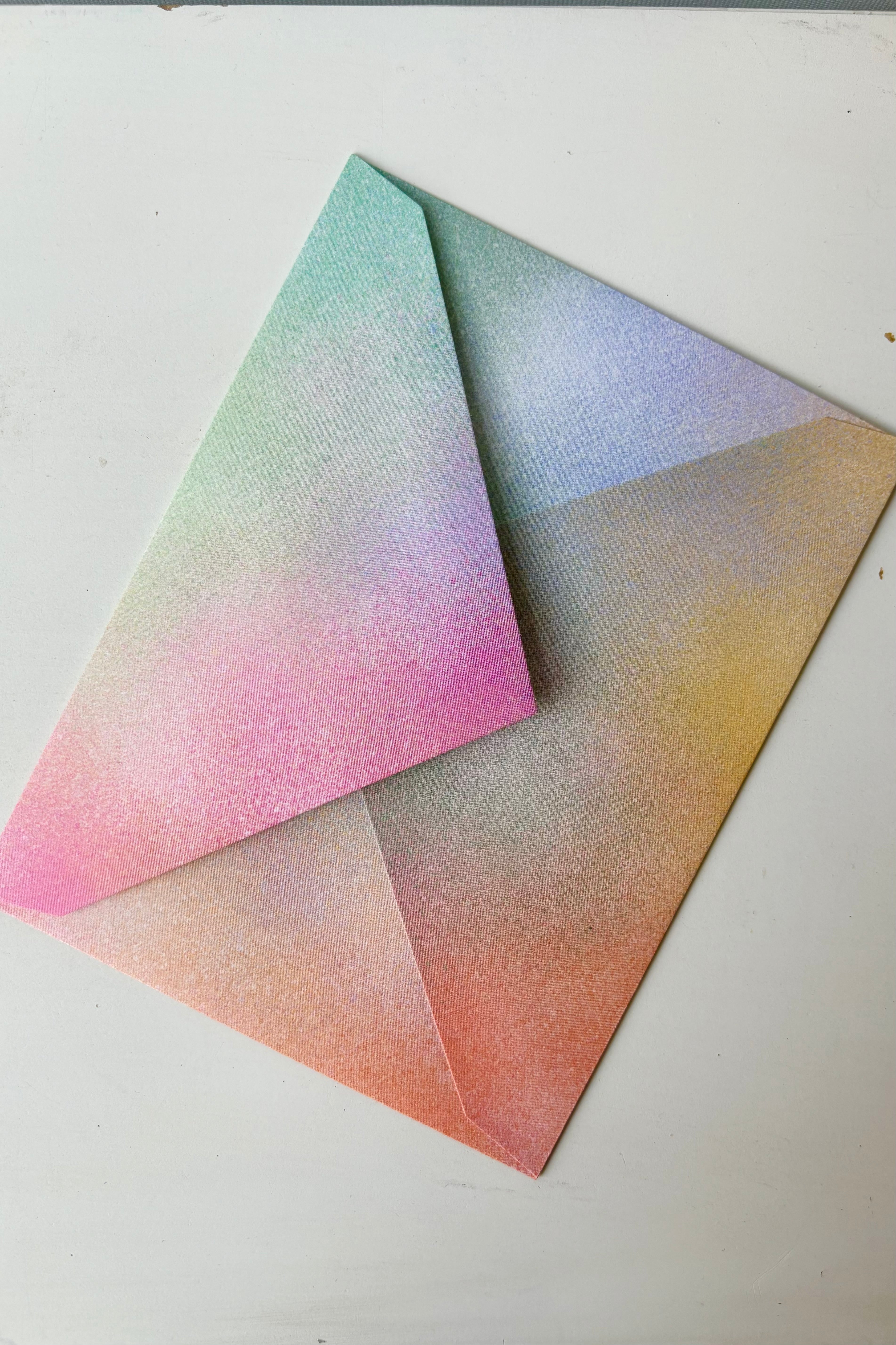 Paper envelope with airbrushed with multicolored pink, orange,yellow, green and blue throughout