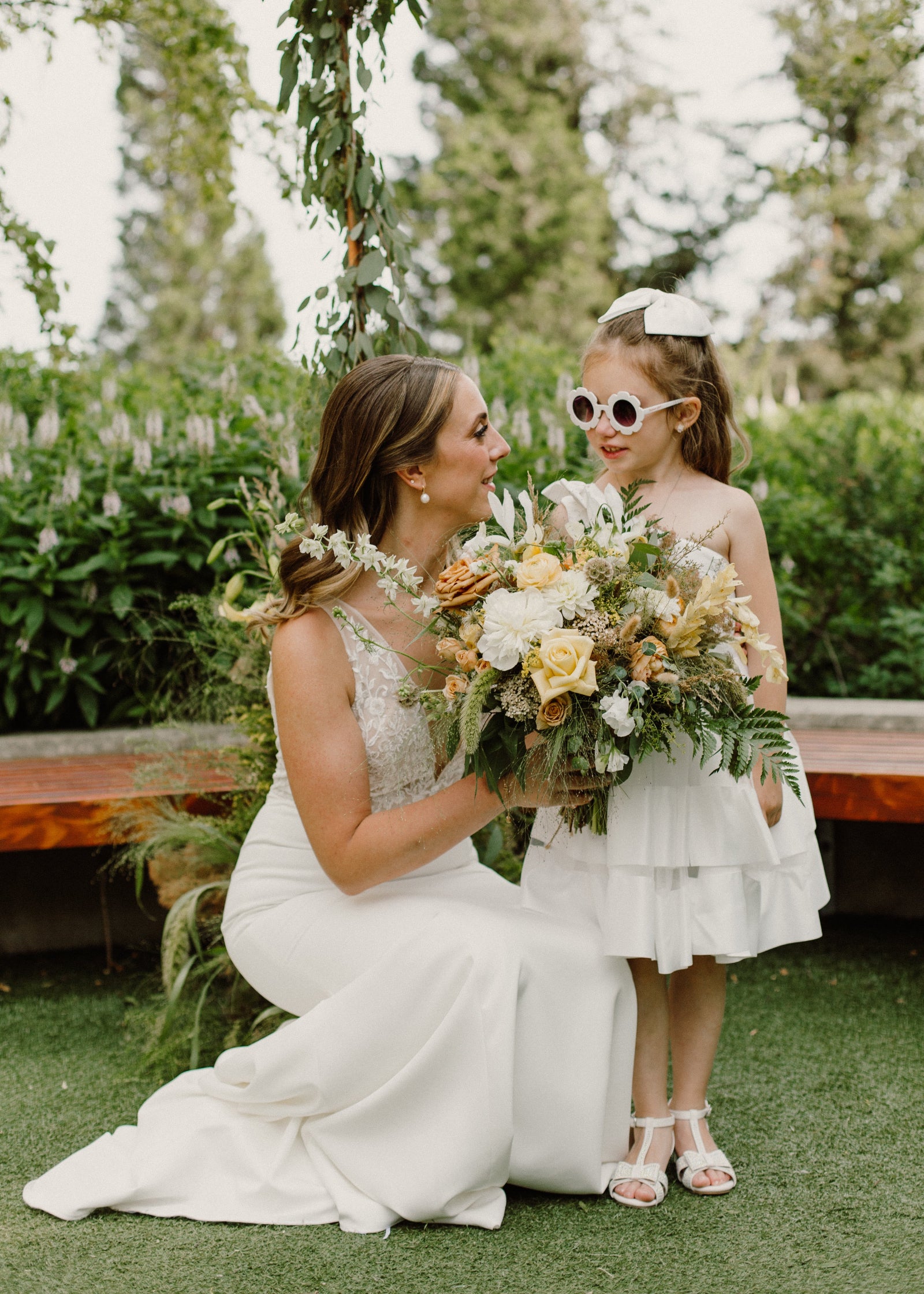 Julia & Vlad's wedding with the bride holding a bouquet next to a young person. Floral by Sprout-home. Photograph by Nicole Donnelly Photography