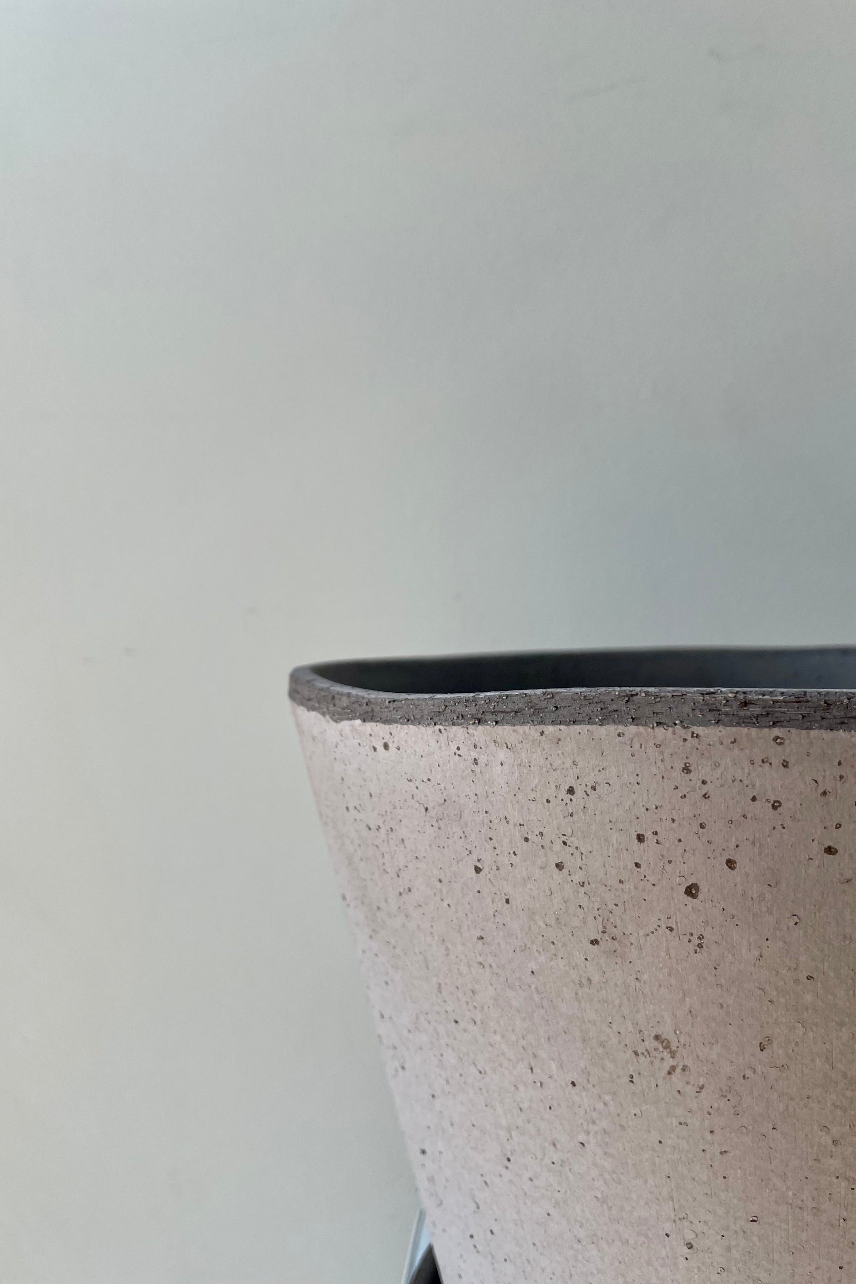 Close up photo of Julie Pot & Saucer grey 9.8” against a white wall