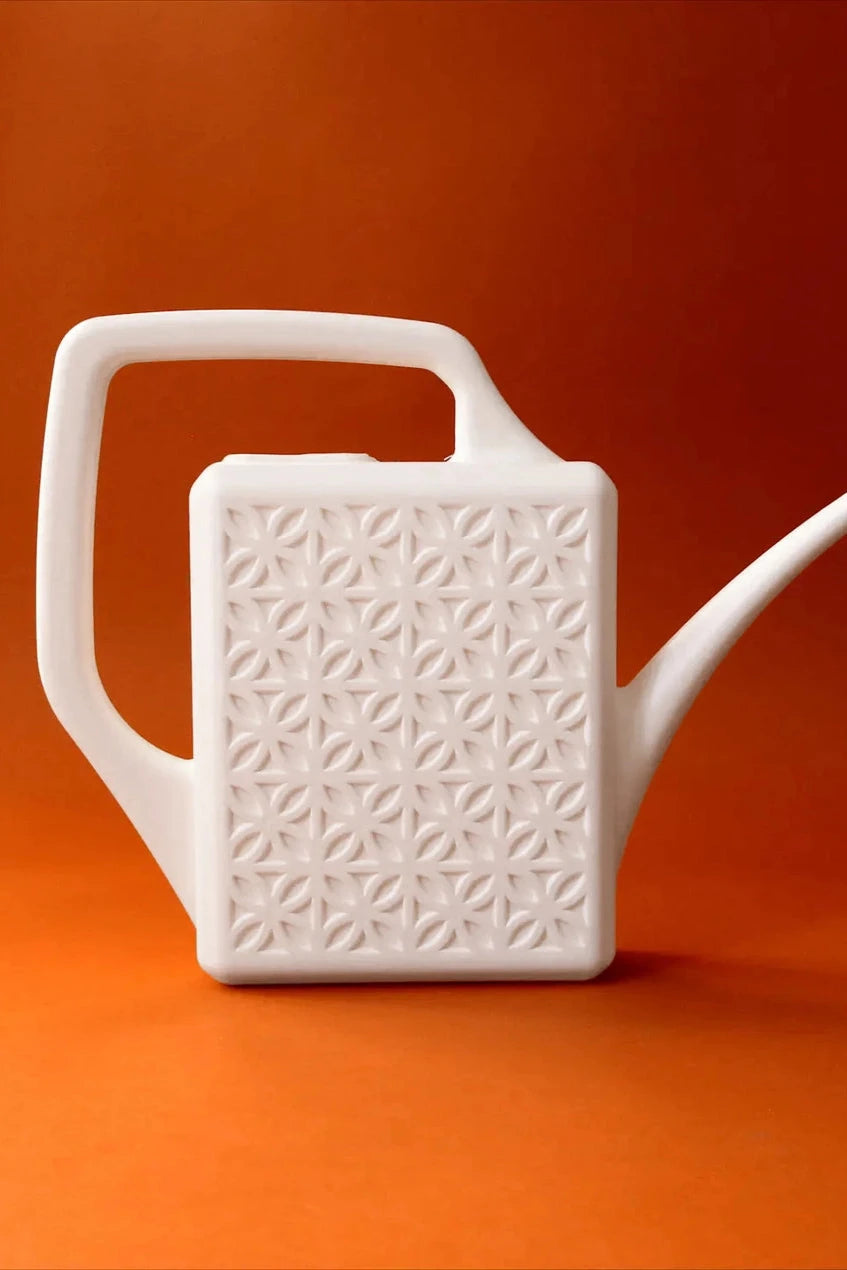 The Breeze Block watering can in Ivory on an orange background by Jungle Club