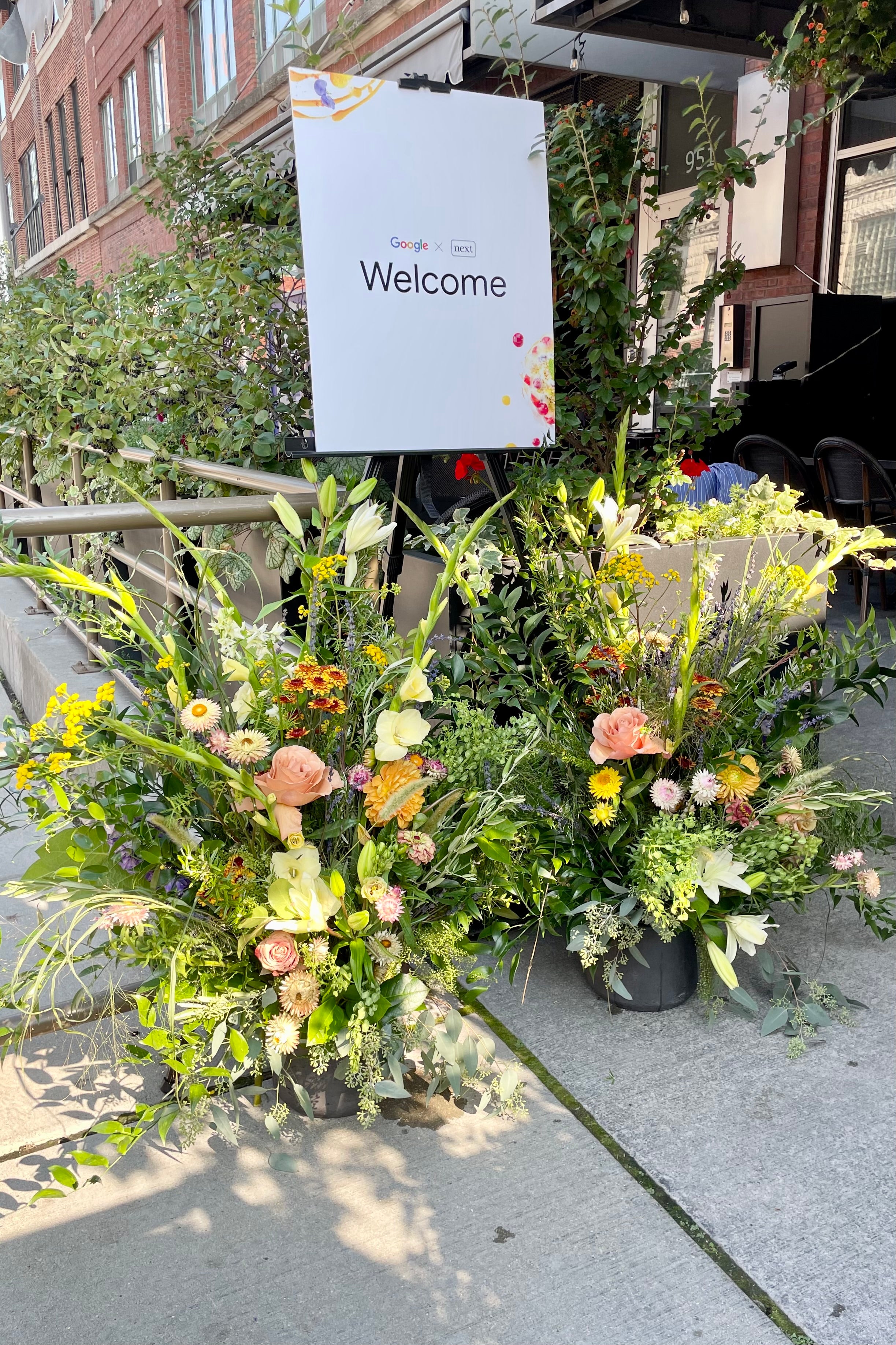 Large welcome arrangements flank a welcome sign for a corporate Google event at Next Restaurant. Photograph by Sprout-home.