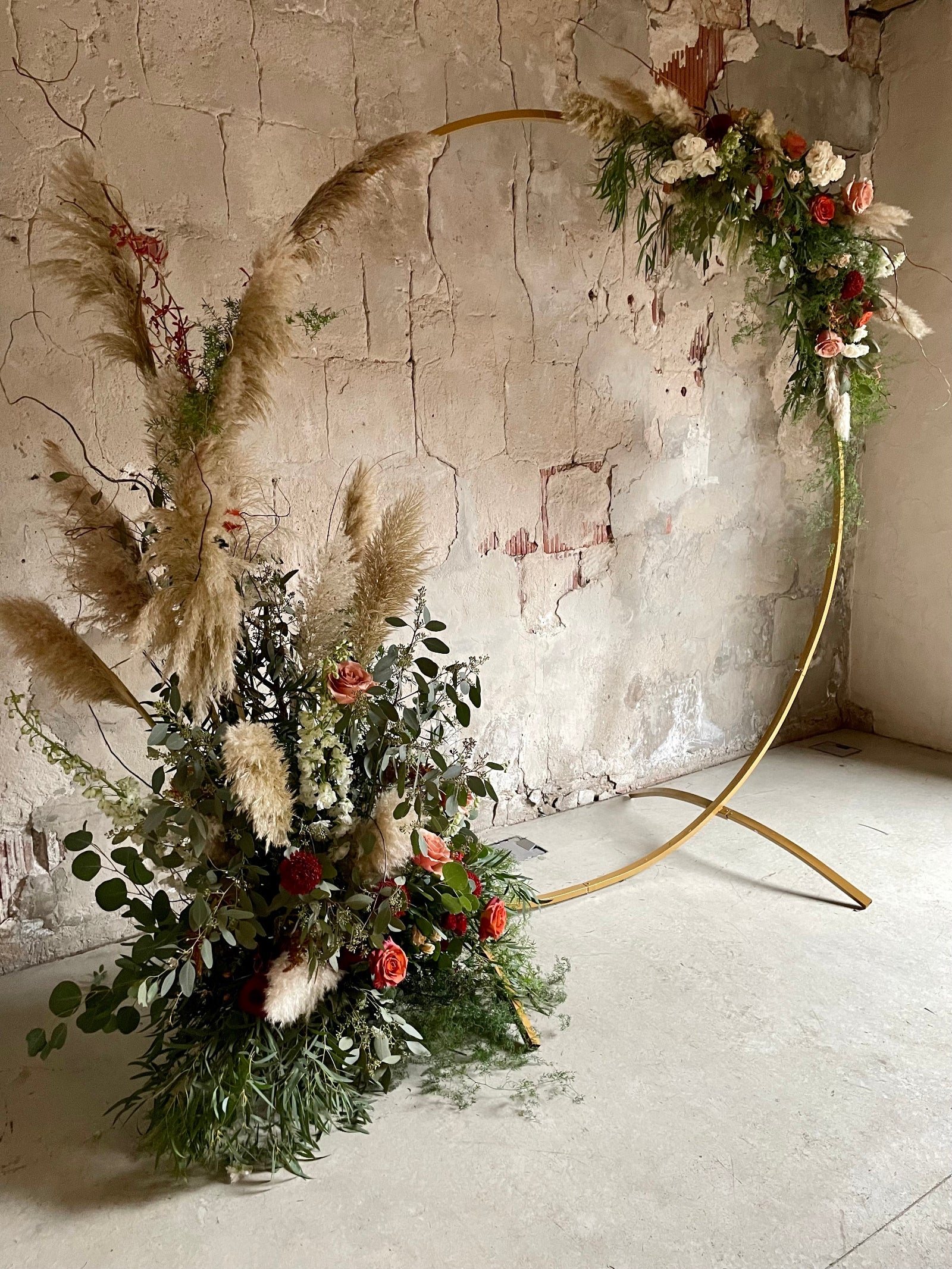 Jennifer Yannick wedding floral by Sprout-home with a golden circle ceremony arch with pampers grass greens and warm colored floral at the Charcoal Factory in Chicago.  