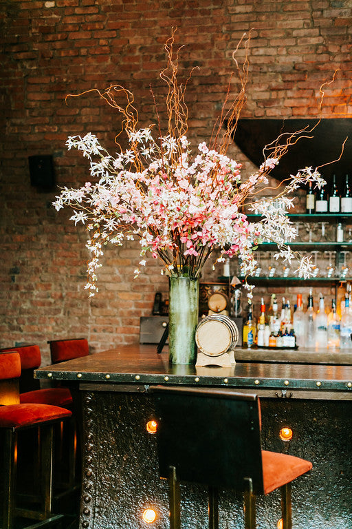 Bar arrangement with white and pink flowering branches by Sprout-home. Photo by Danfredo Photos Films.