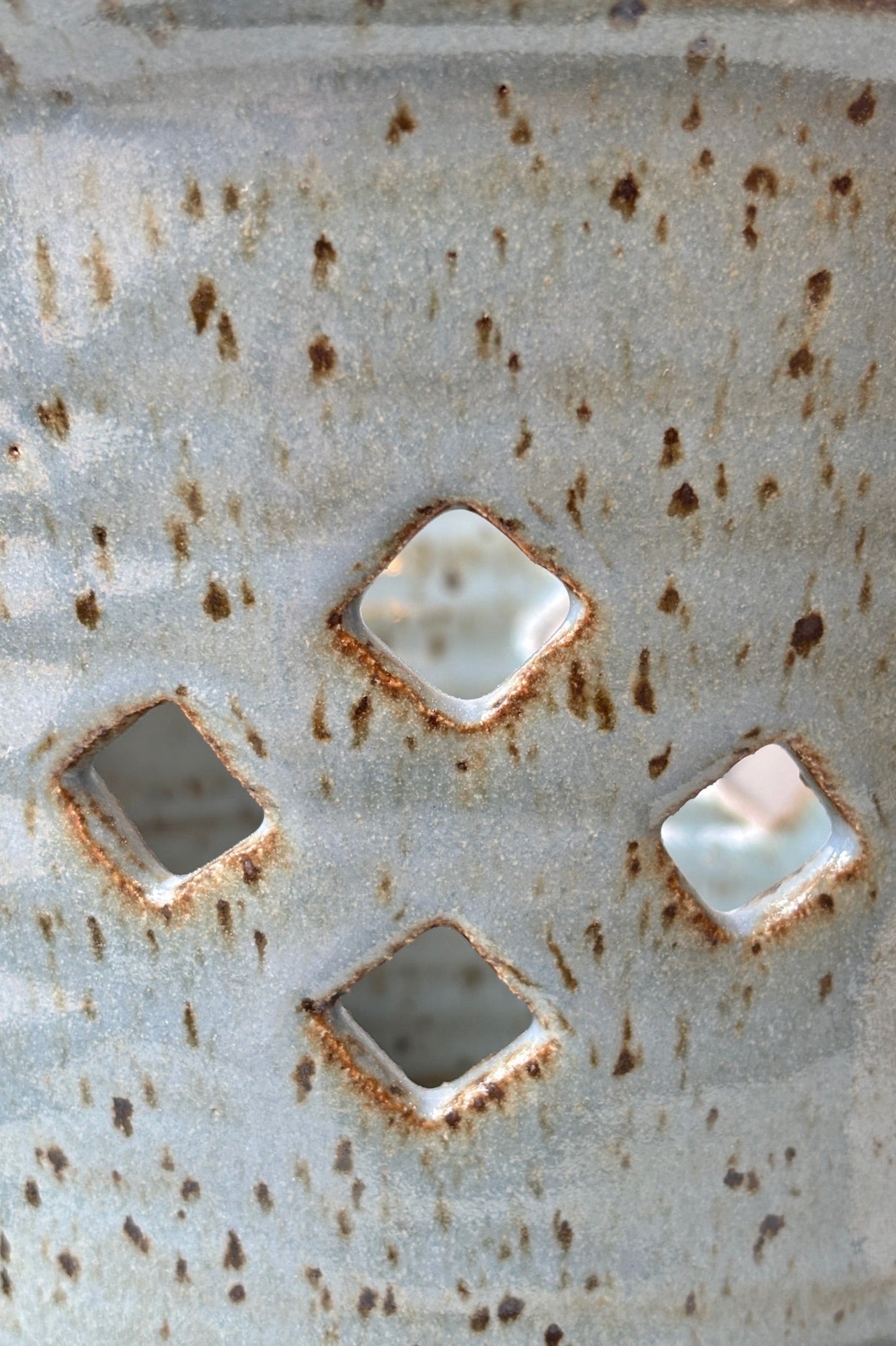 Close up of glaze and diamond pattern air holes on the side of the glazed conflower 7" orchid pot  ©sprout home