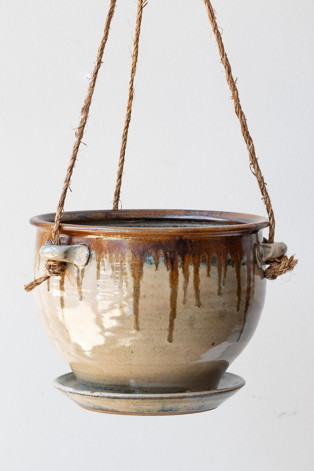 Detail of Bruning Pottery Hanging Planter ivory & iron glaze - 8" held in front of white wall