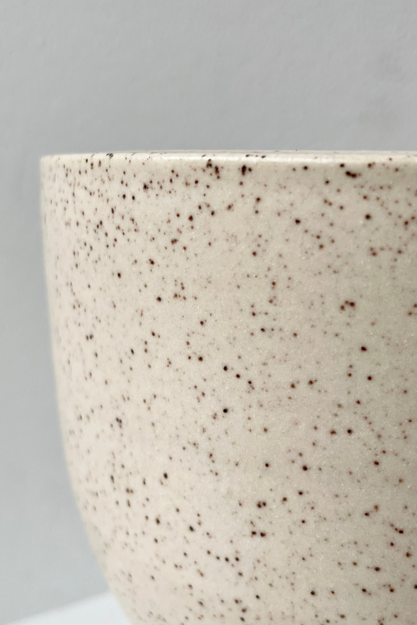 Detail of the finish of Cream Speckle on the tabletop an saucer planter. 