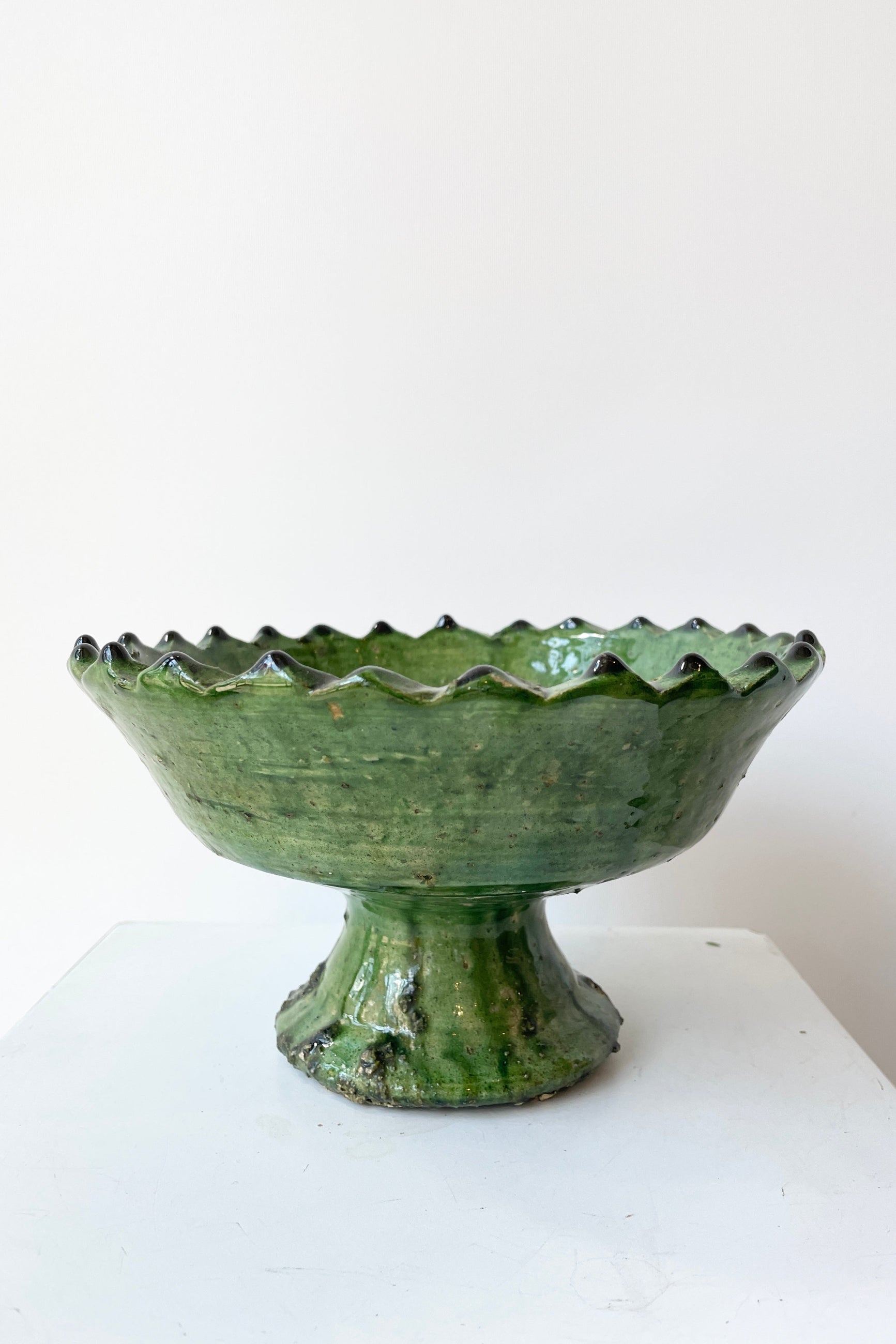 The Tamegroute Green compote at Sprout-home viewed from the side at eye level against a white wall. 