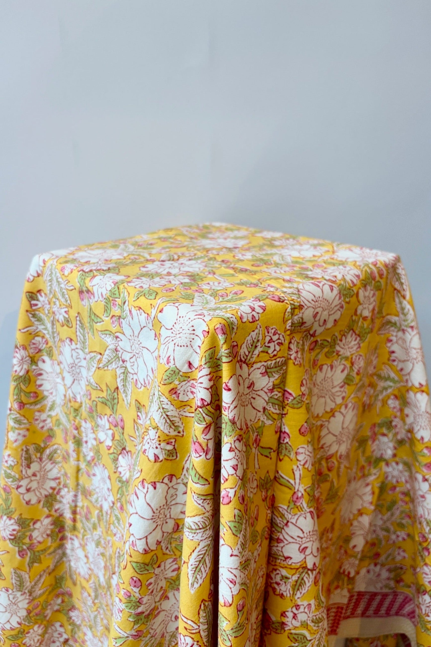 Hand printed, 100% cotton Camelia  yellow and pink floral print tablecloth styled on a table ©Sprout Home
