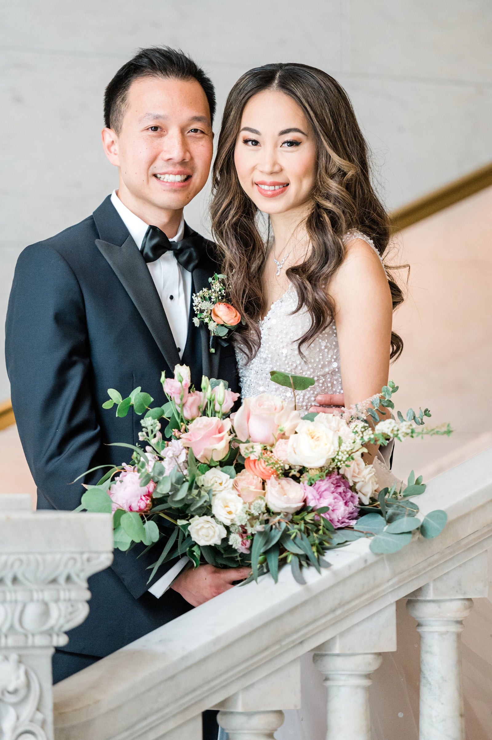 Yan and Andrew wedding at the Ivy Room in Chicago. Portrait of the bride and groom on a staircase holding a bridal bouquet featuring eucalyptus, cream and pink roses and peony amongst other floral by Sprout-home. Photograph by Ana Maria Vieriu Photography