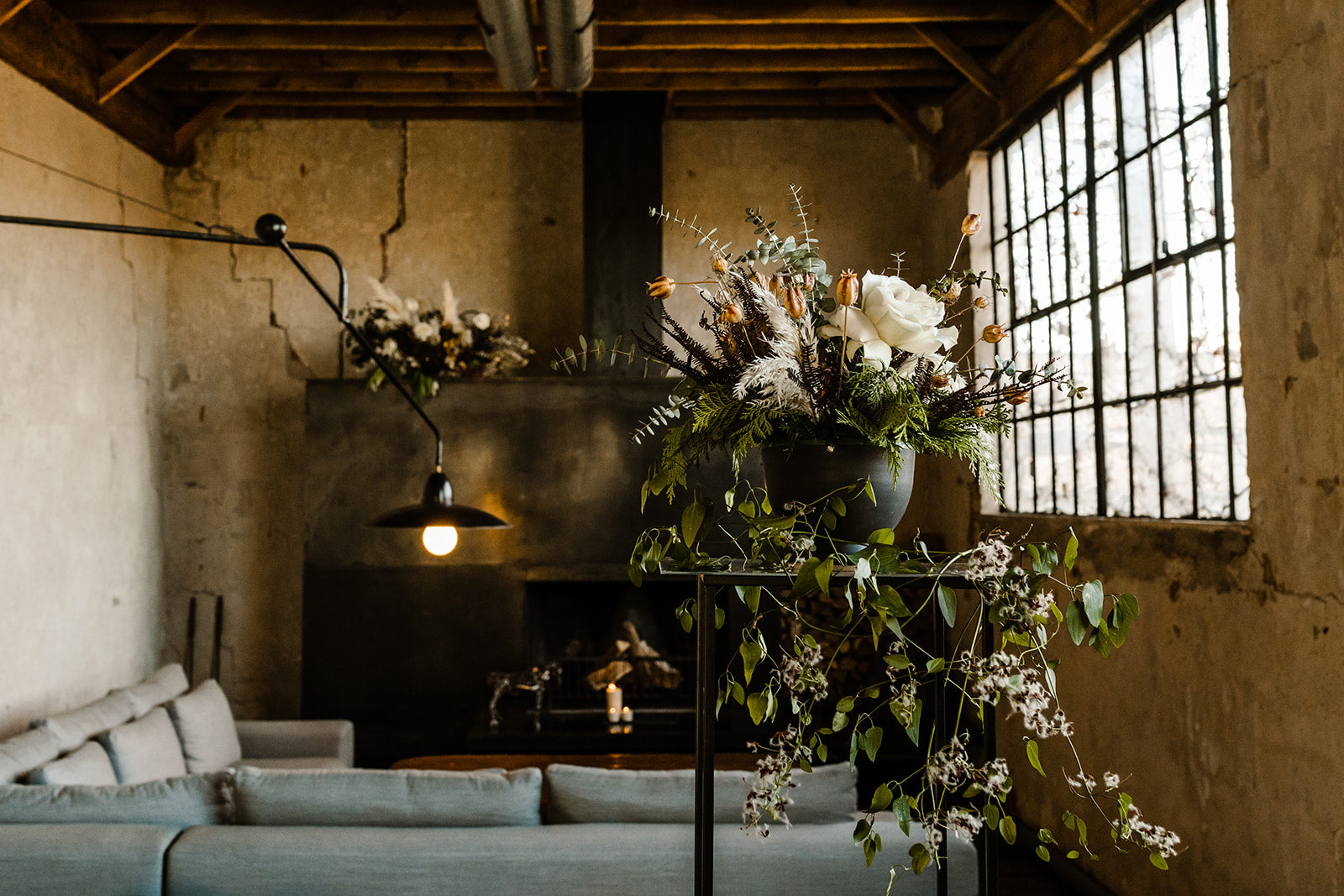 Todd & Michael elopement floral by Sprout-home. White and winter floral and greenery on a pedestal and fireplace mantel.  Photo by TM Inspired Photography