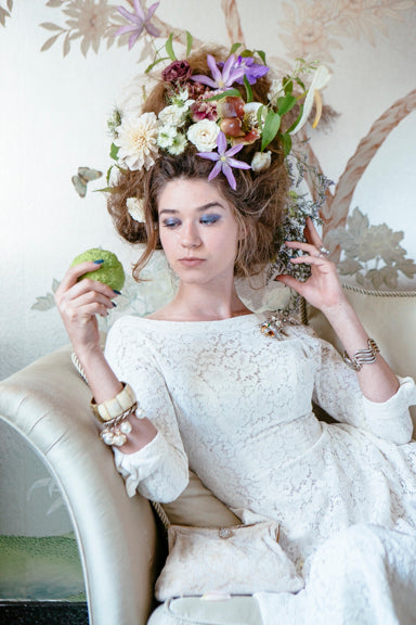 Floral photoshoot by Sprout-home at the Women's Athletic Club of Chicago photographed by Heather Talbert. Floral hair with model lounging on on chaise. Baroque and romantic.