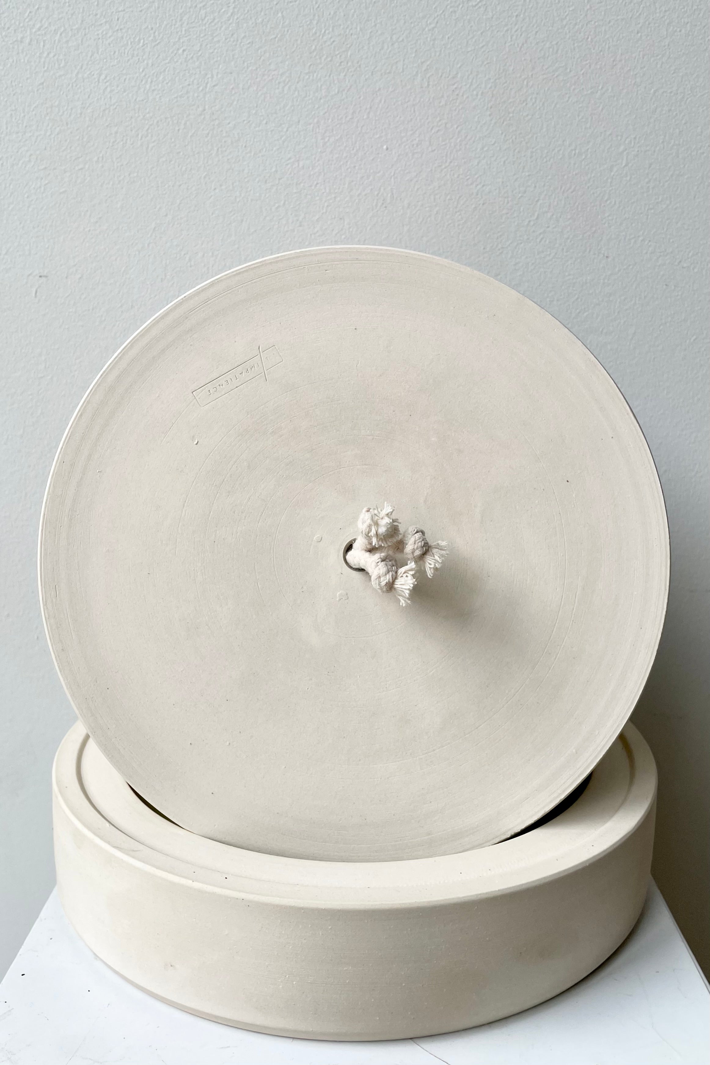 White wide self watering planter pictured showing the bottom of the planter with the wick 