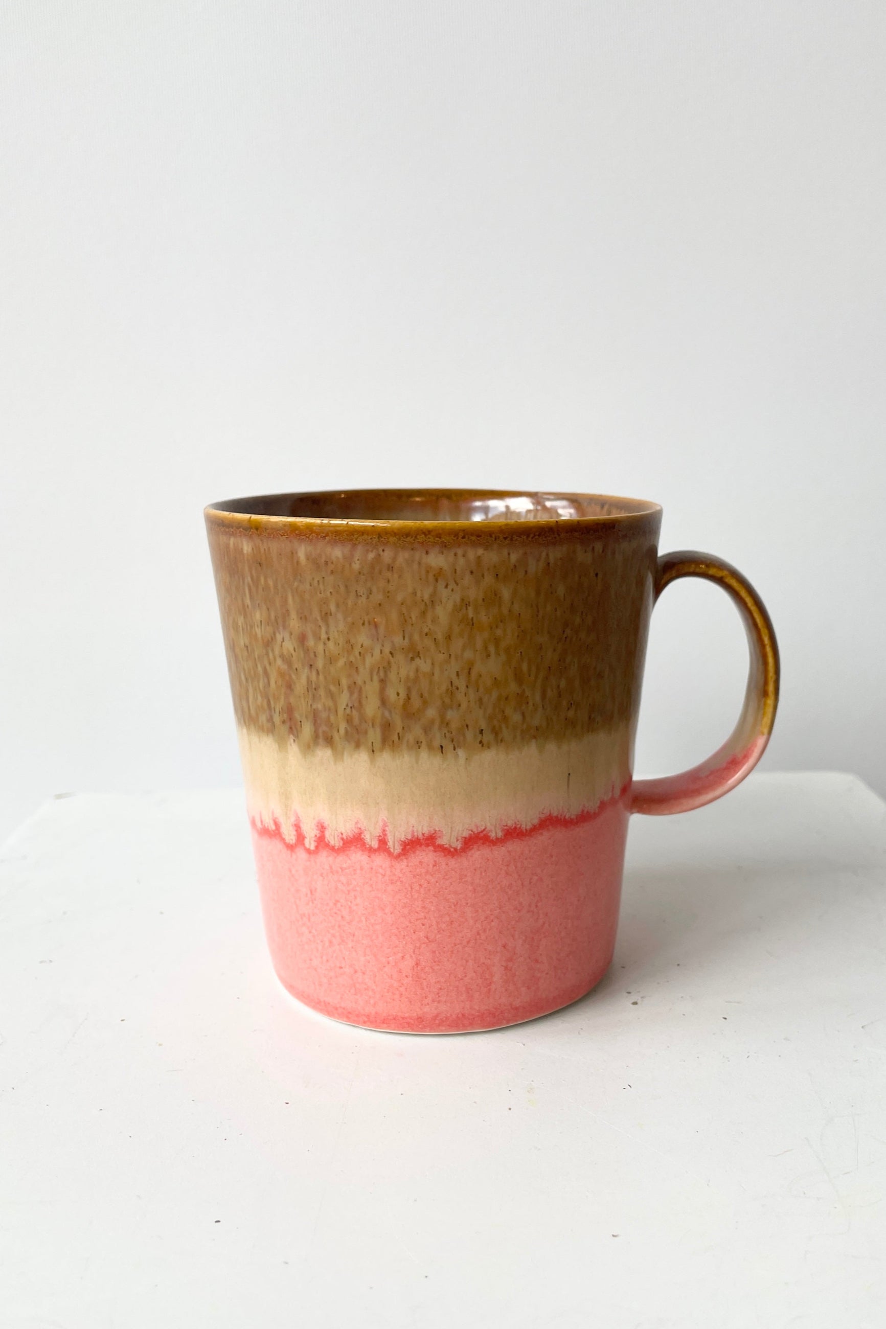 The YT006 Mug with is handglazed rings of pink and brown viewed from the side. 