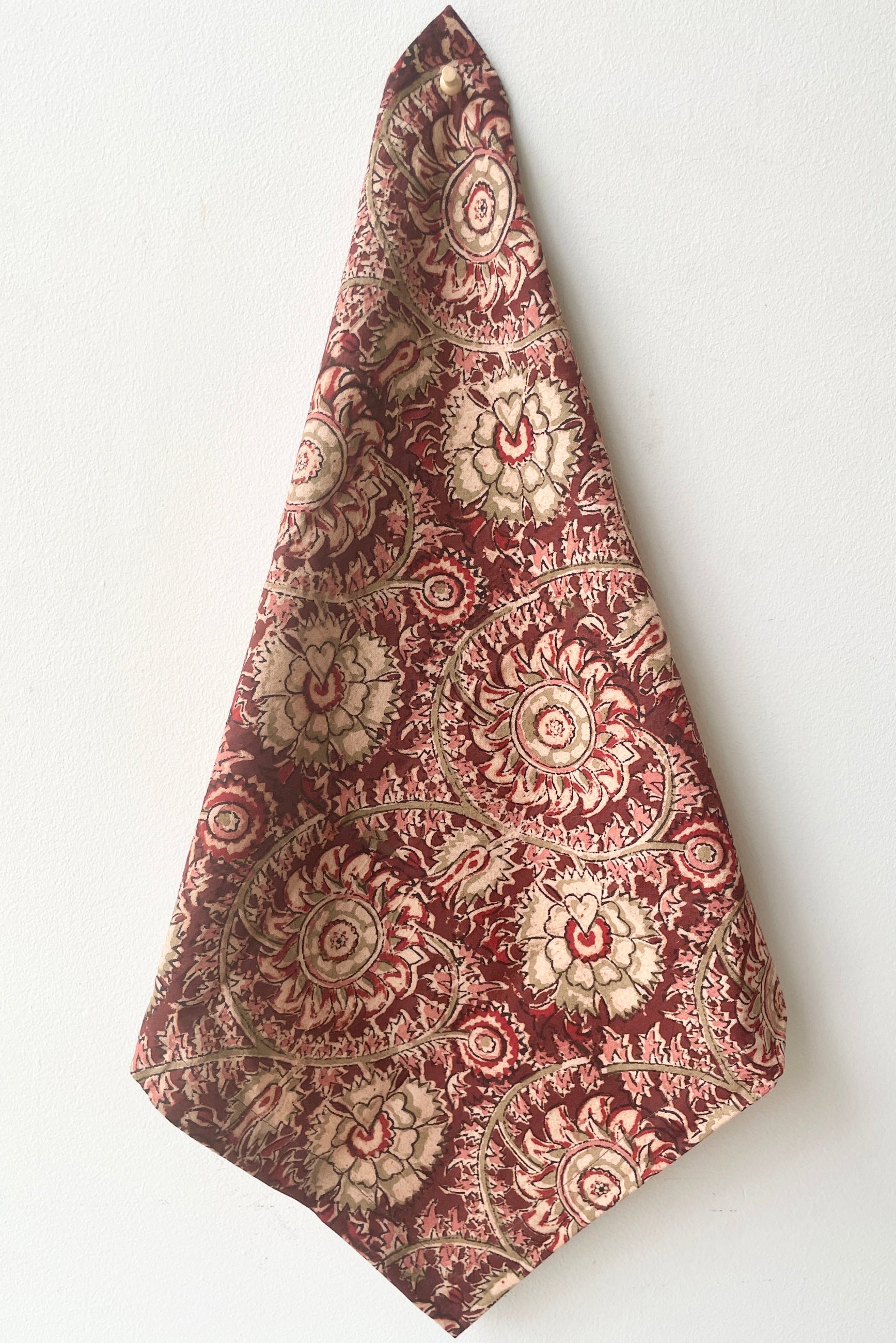 The Adah napkin lela hanging in front of a white wall. 