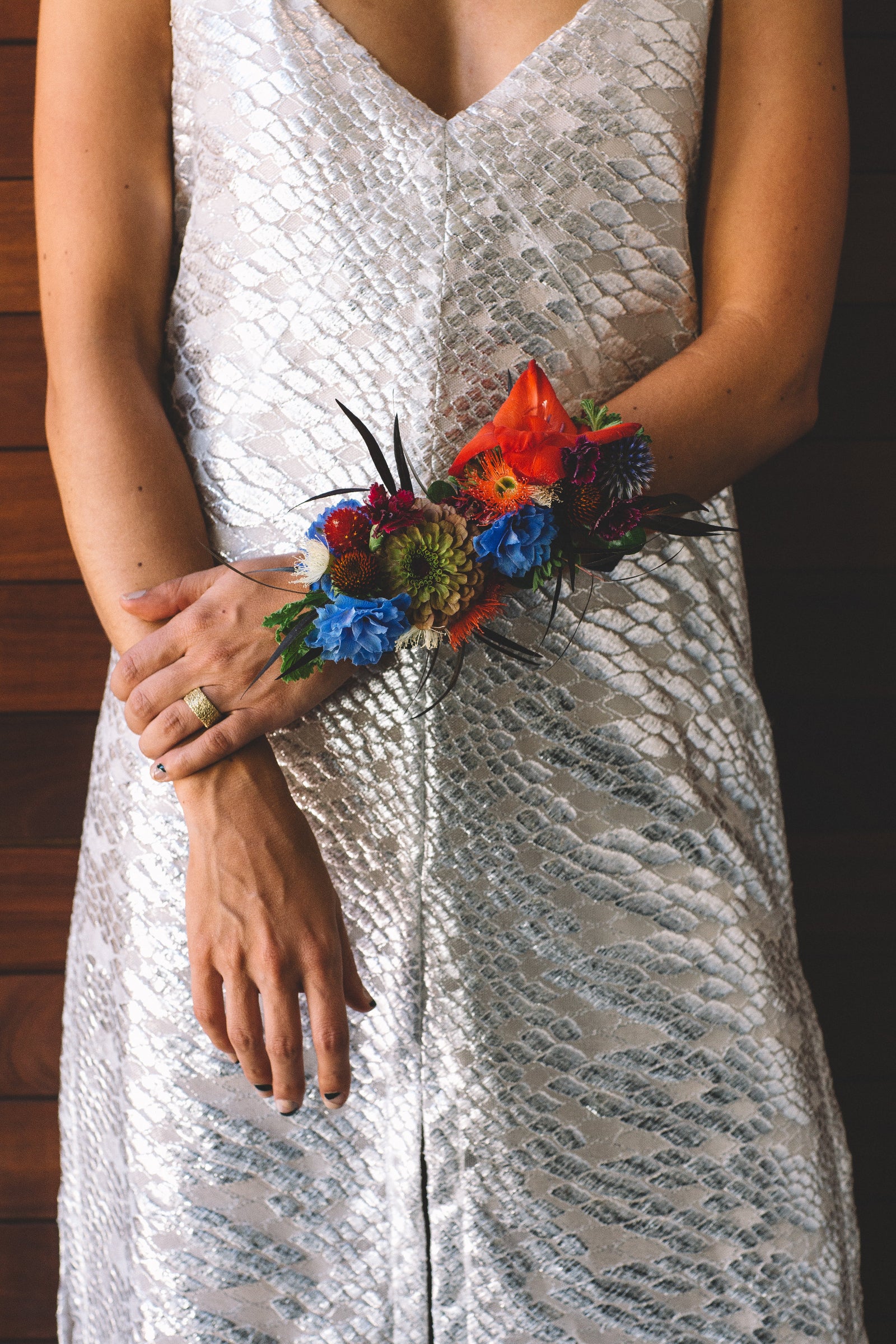 Sprout-home wrist floral arrangement in bright red and blue. Photographed by Stephanie Bassos