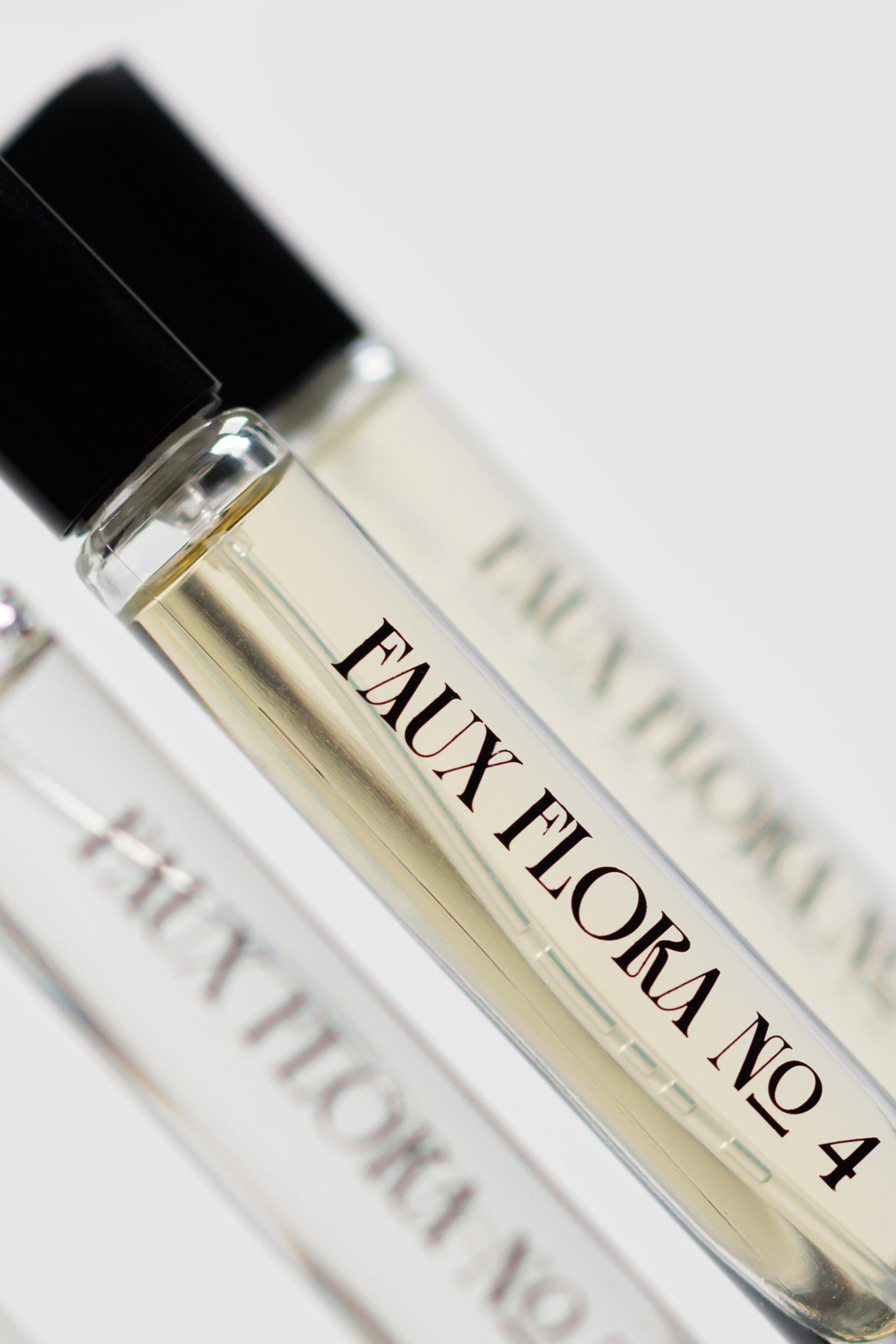 Three small perfume bottles labeled, one being the  'Faux Flora No. 4' of the Faux Floral Discovery Set on a light background. ©Fischersund