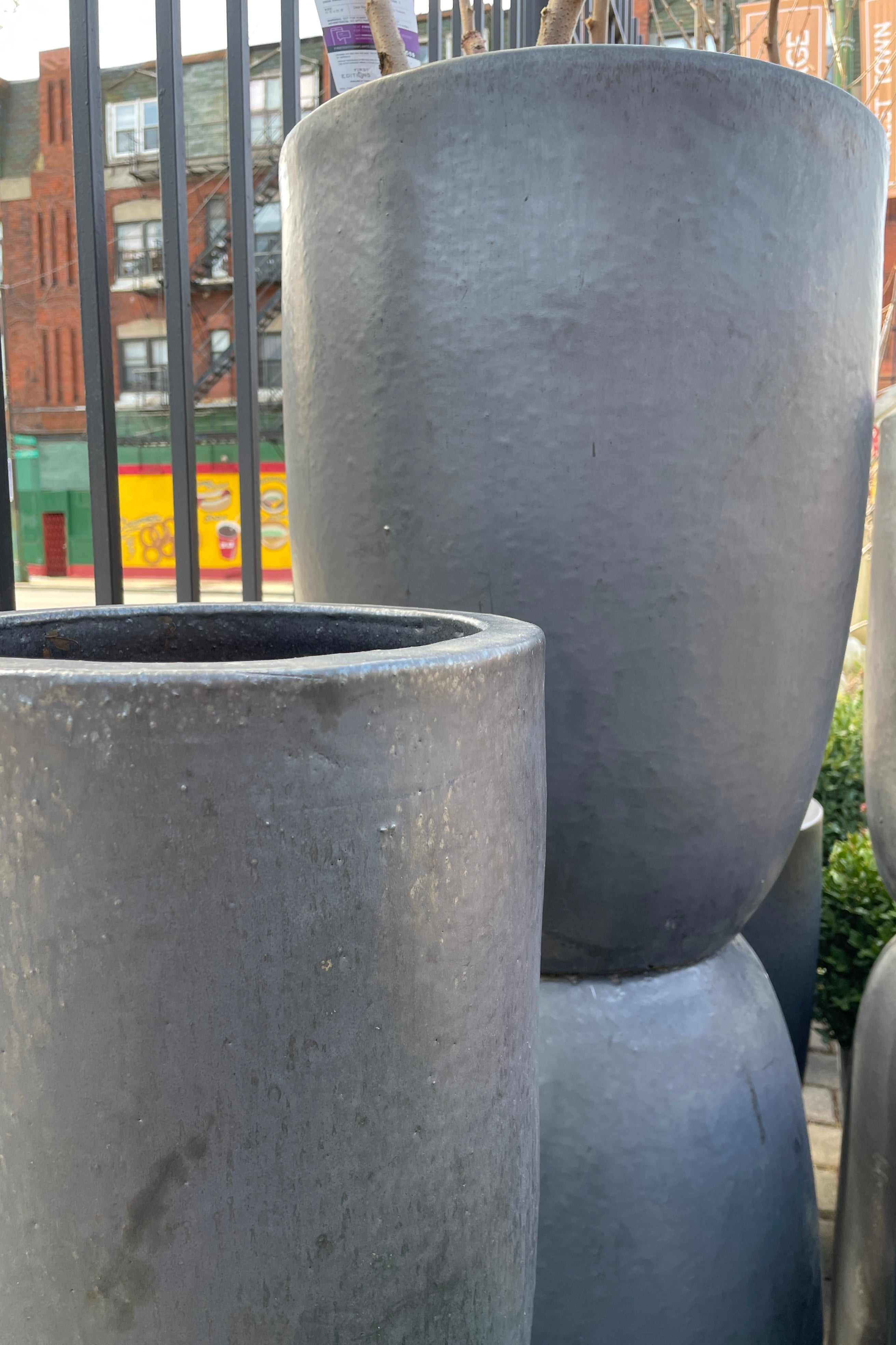 A group of Graphite crucible planters stacked without plant material in the Sprout-home yard. 