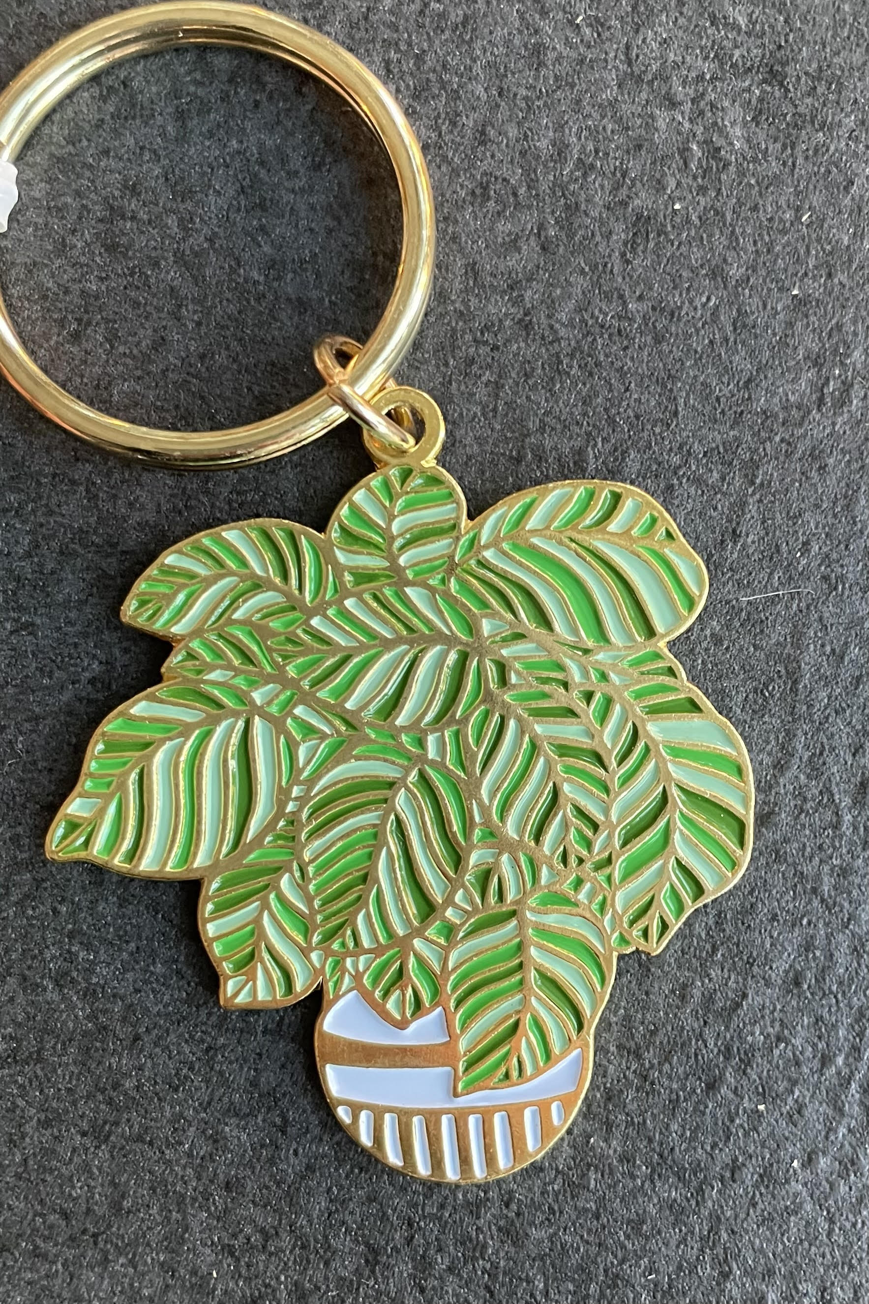 The Plant Keychain against a grey, felt background
