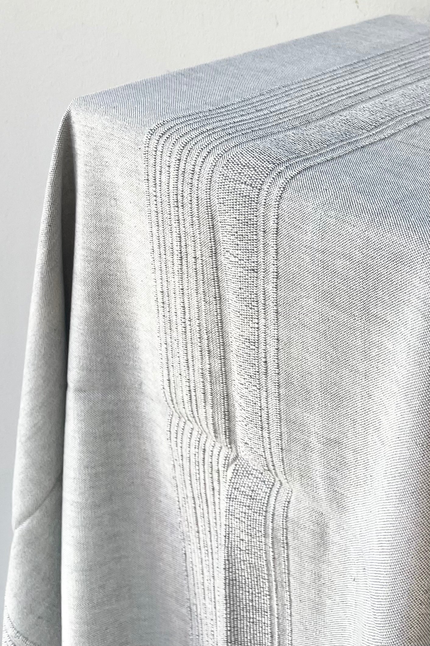 Tablecloth sea salt large draped over the corner of a table against a white wall