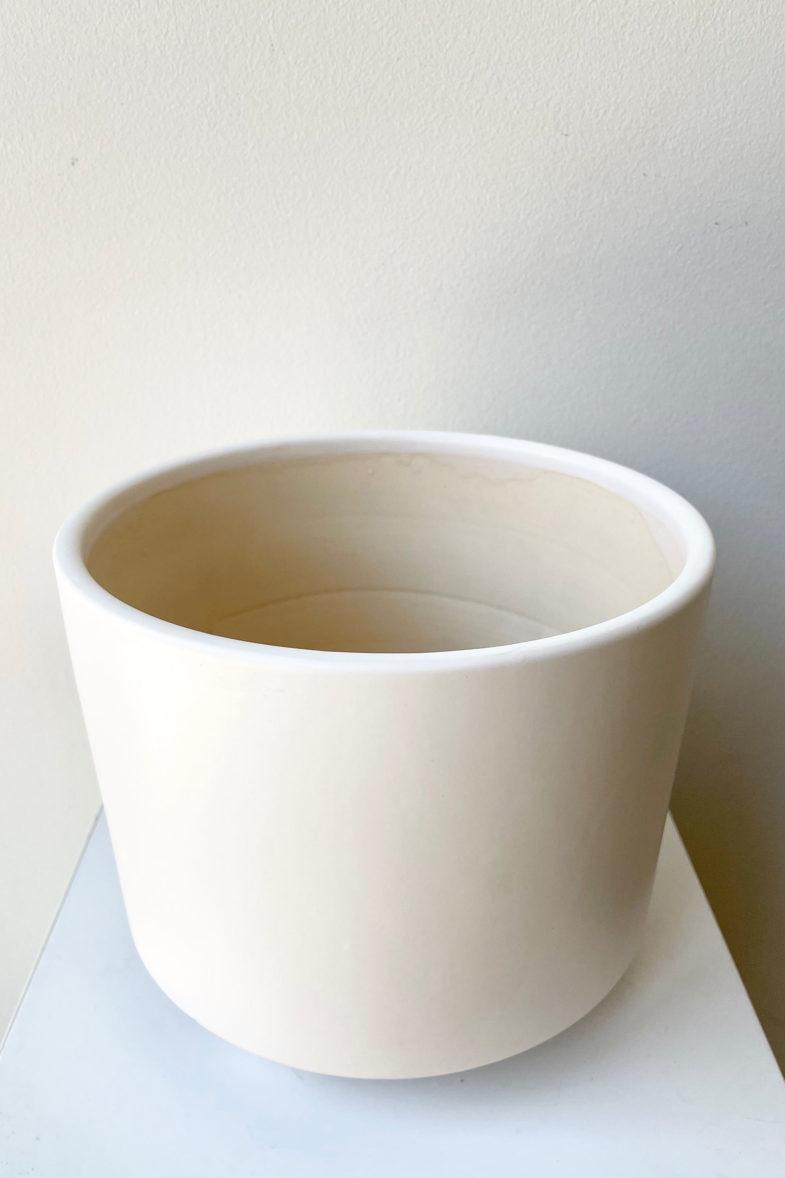 The large white Simon footed planter against a white wall at Sprout-home.