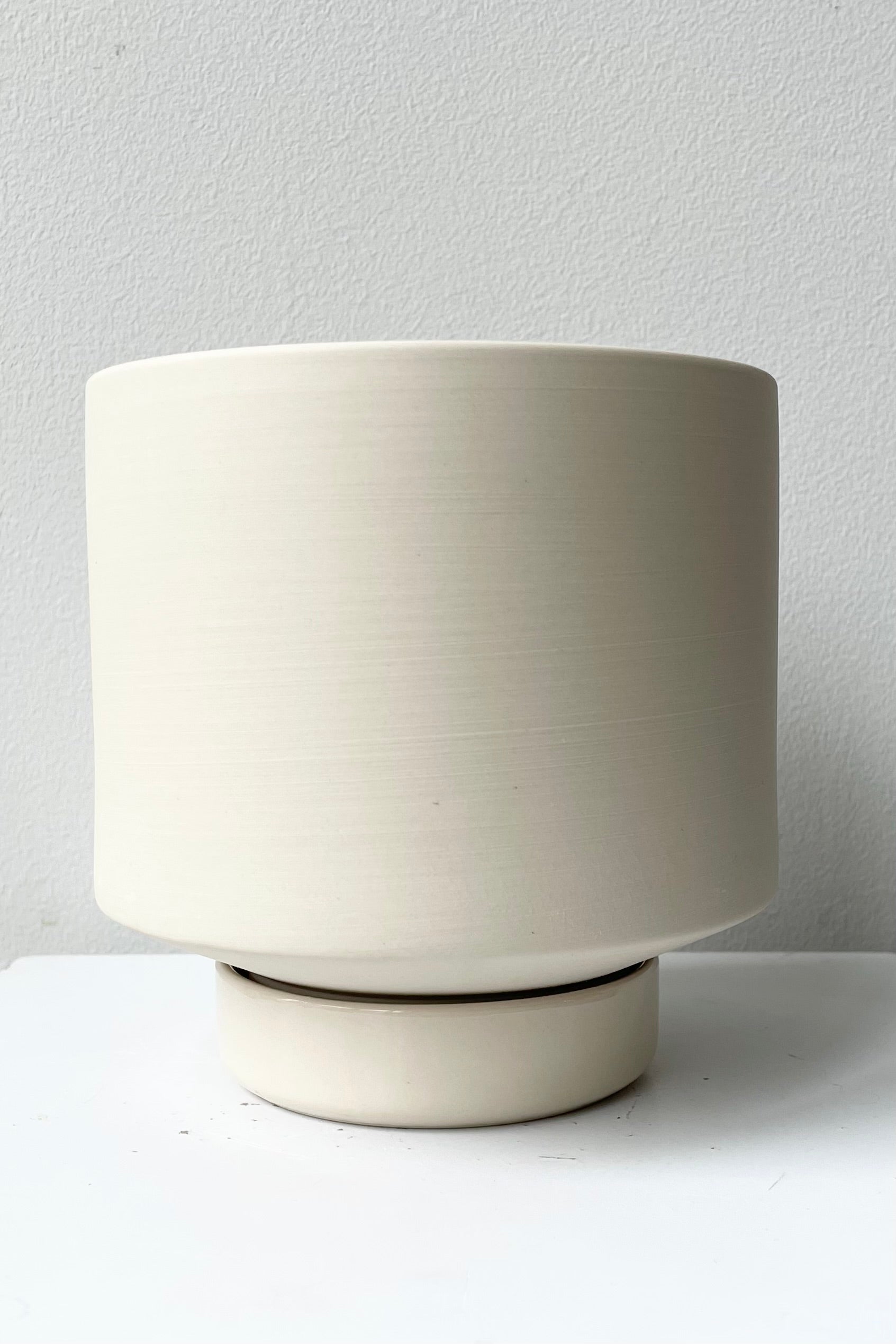 Clay color Collectors Group Pot against a white wall. 