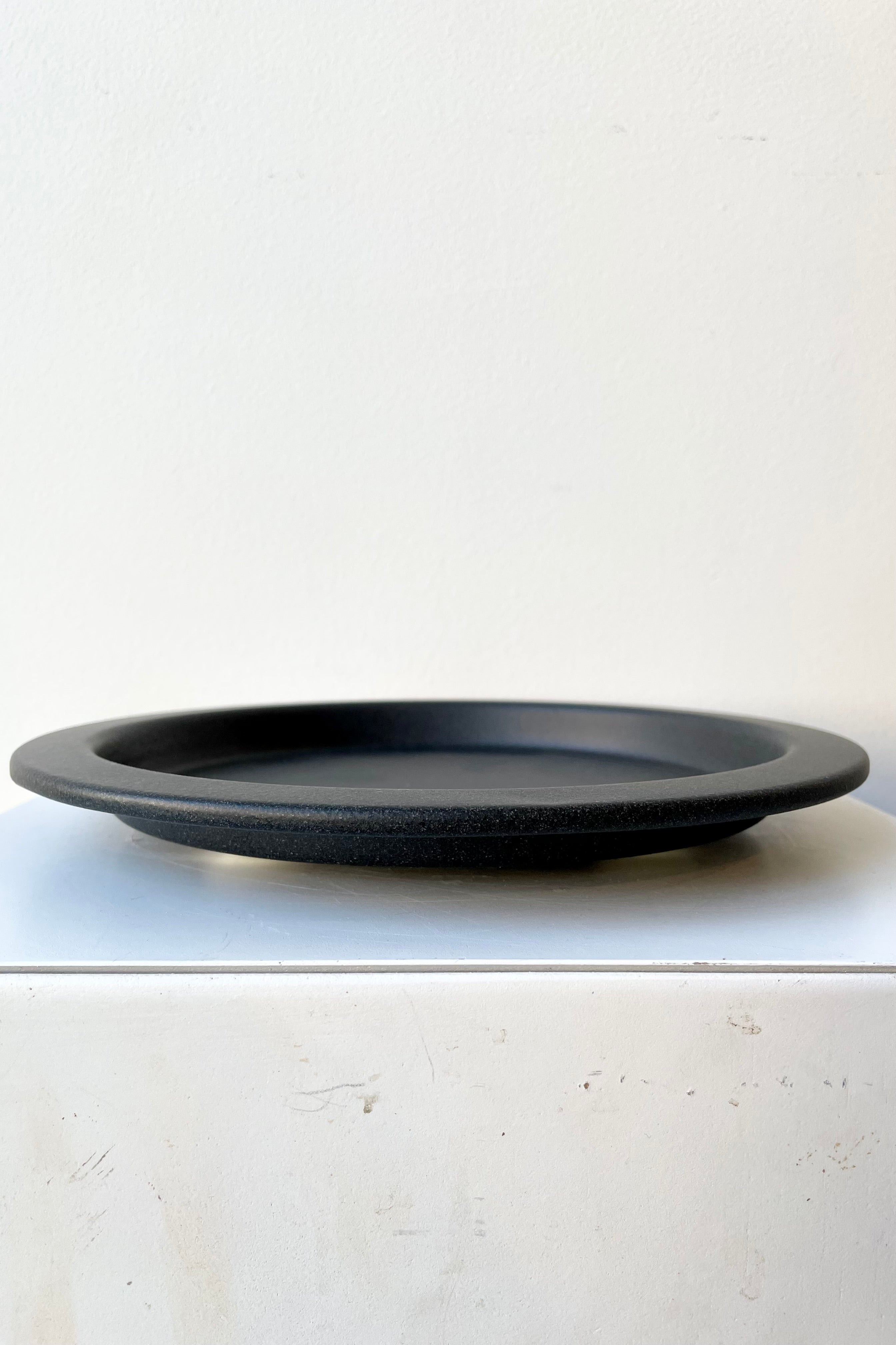 8" speckled grey saucer against a white wall at Sprout-home.