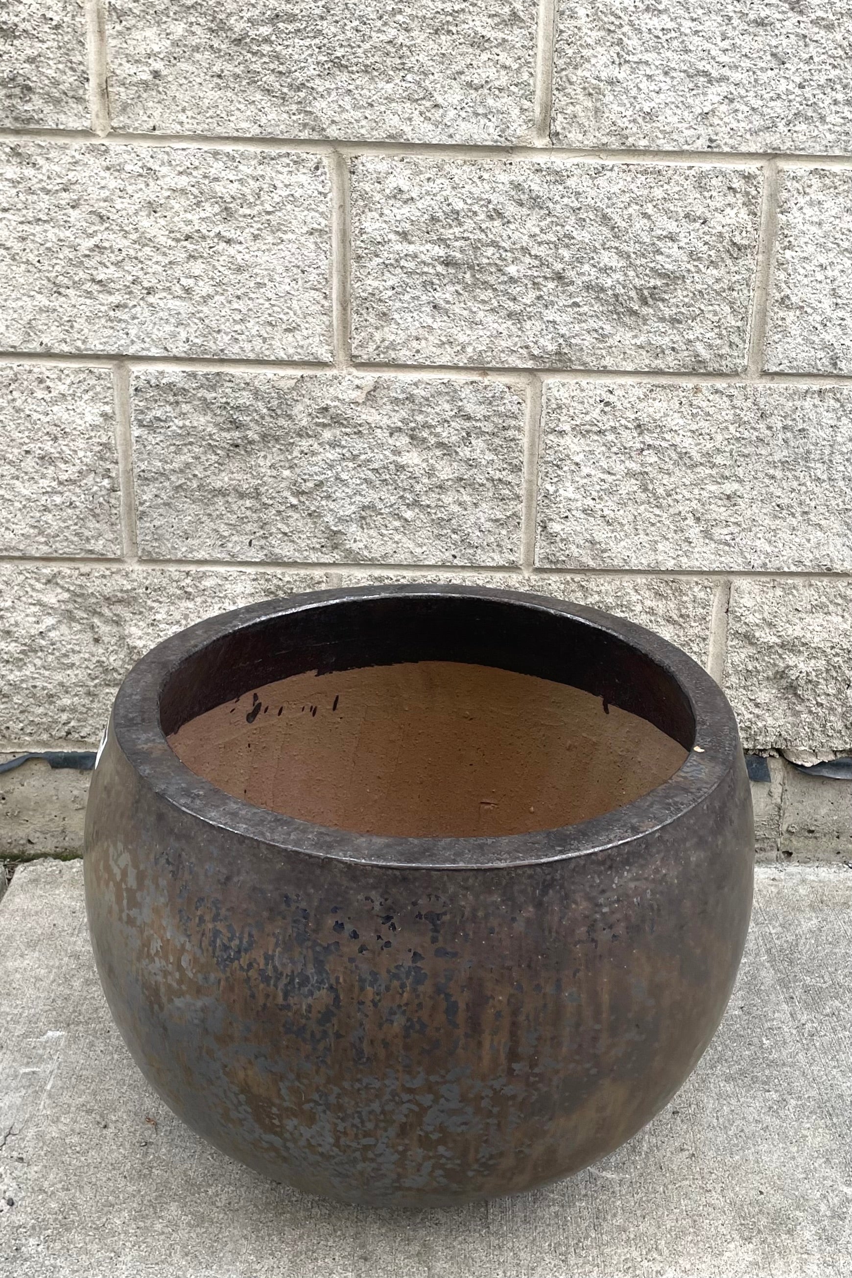 A slight overhead view of Luna Cercle Planter Large against concrete backdrop